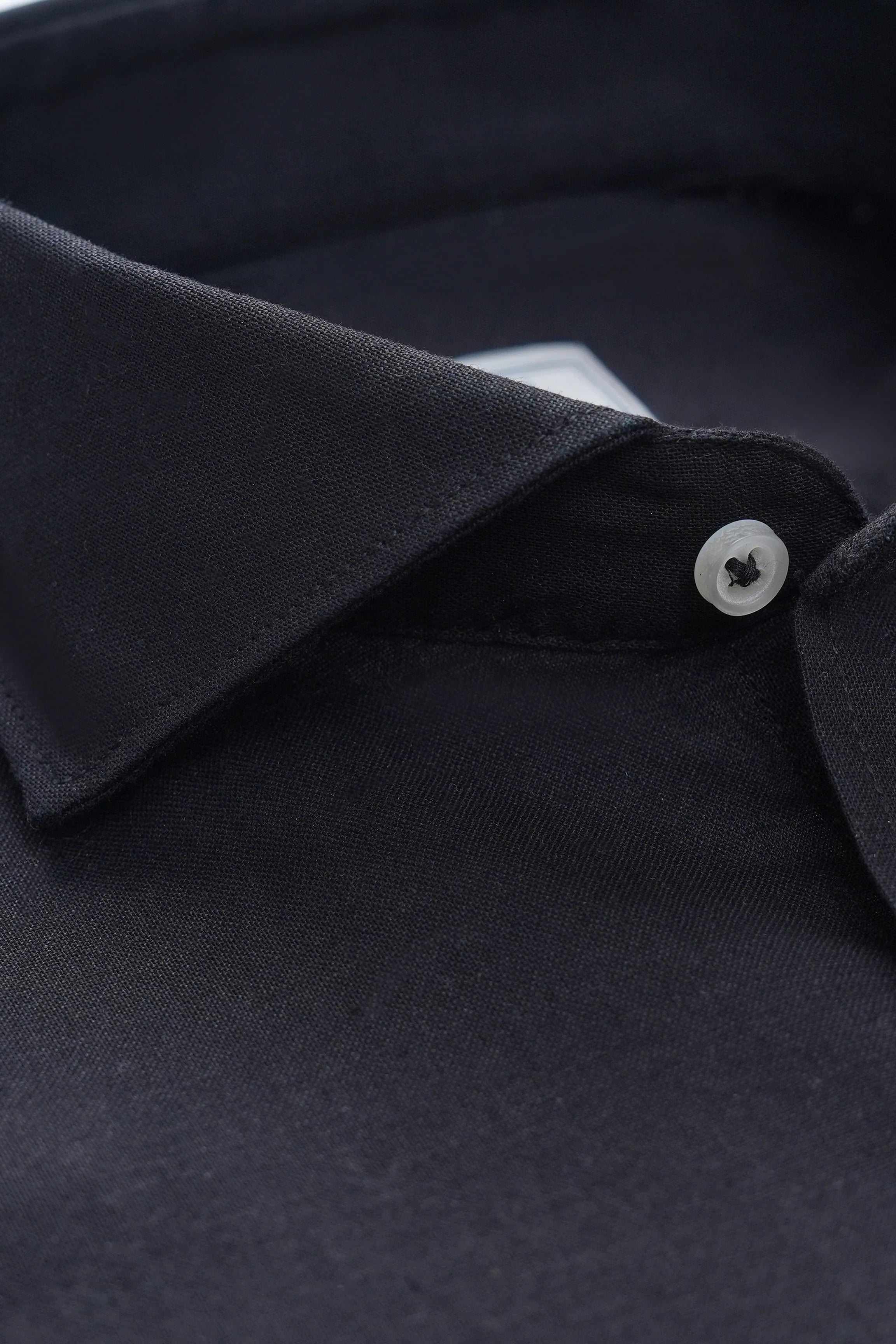 Close-up of black linen wide spread collar and button placket