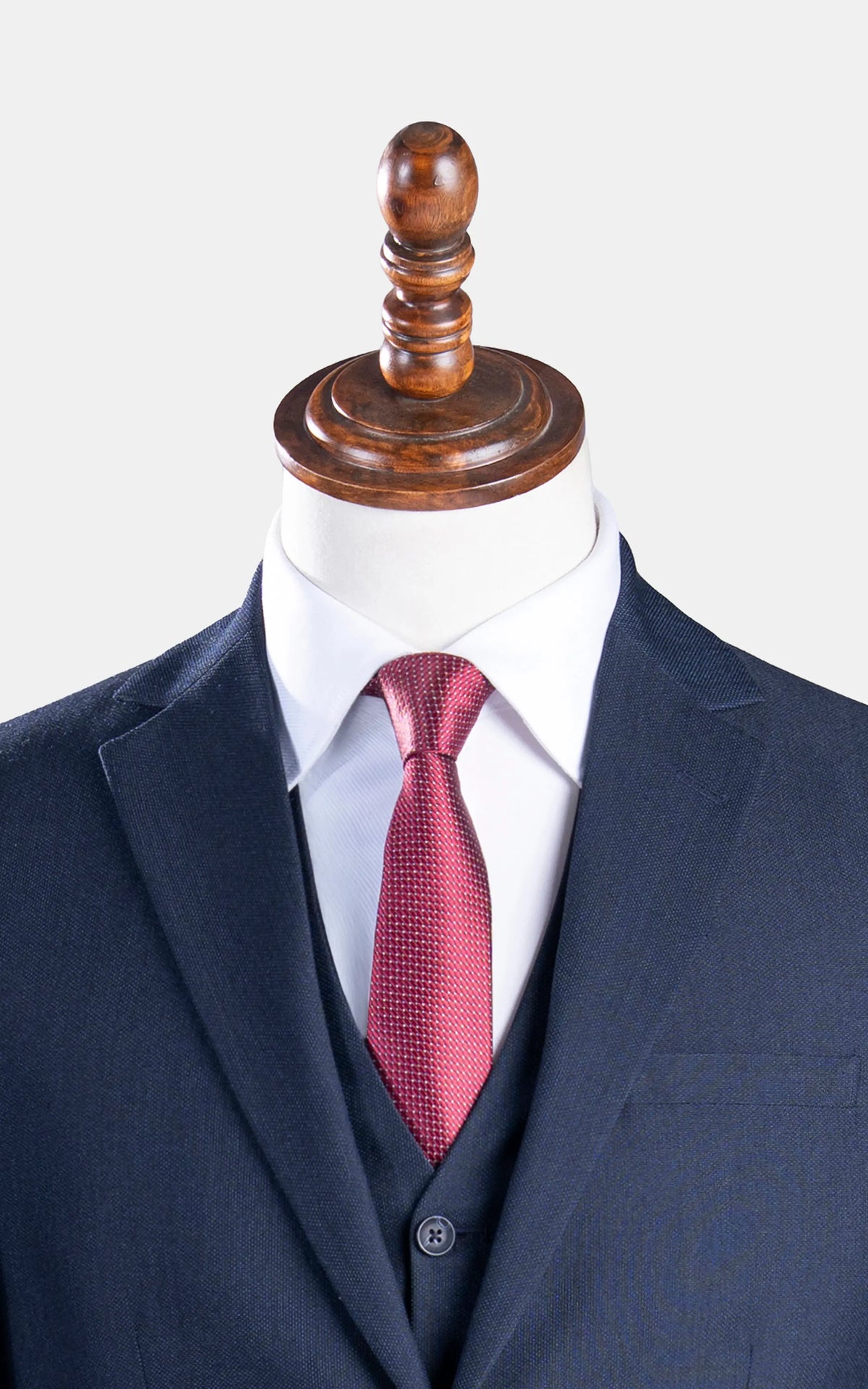 Dark navy suit jacket lapels with red textured necktie and white dress shirt