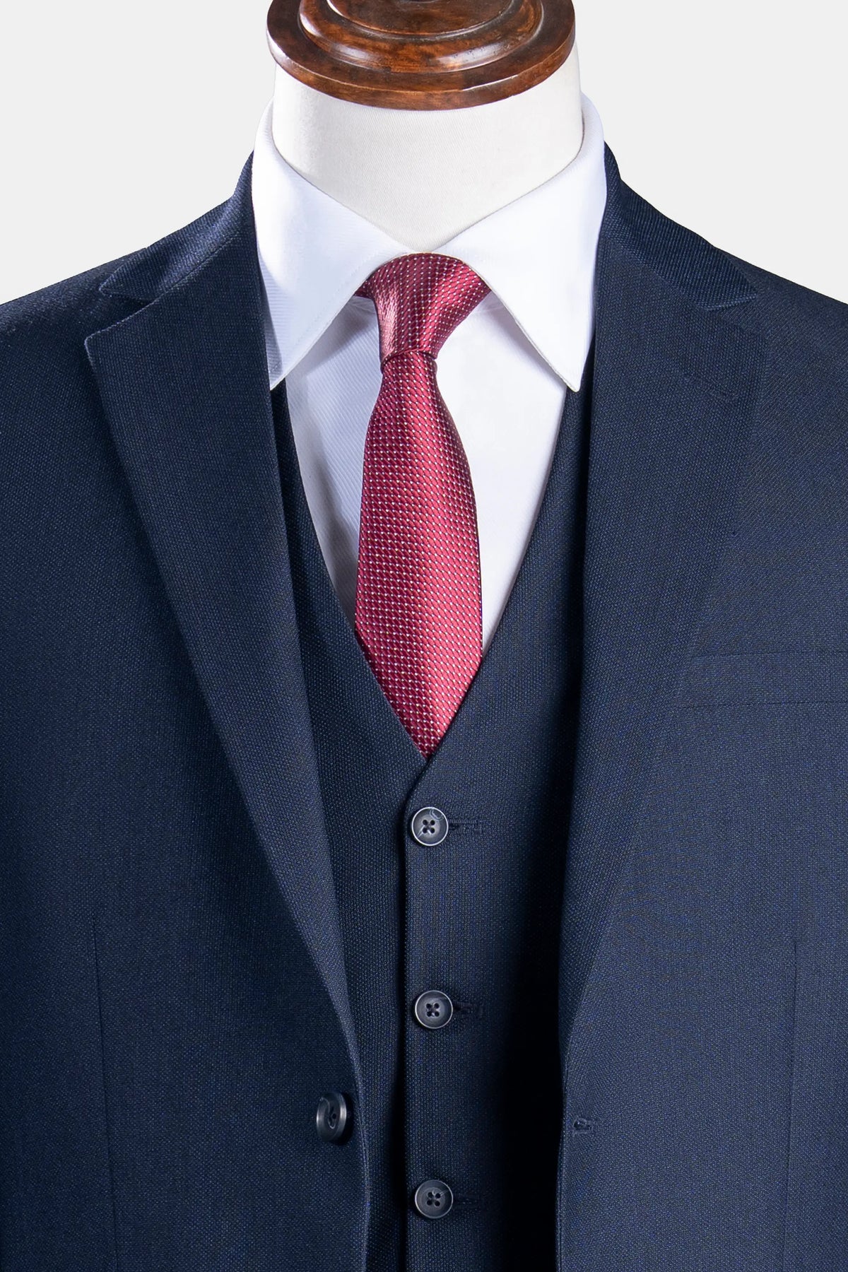 Dark navy suit vest with three-button front and red tie, beneath matching jacket