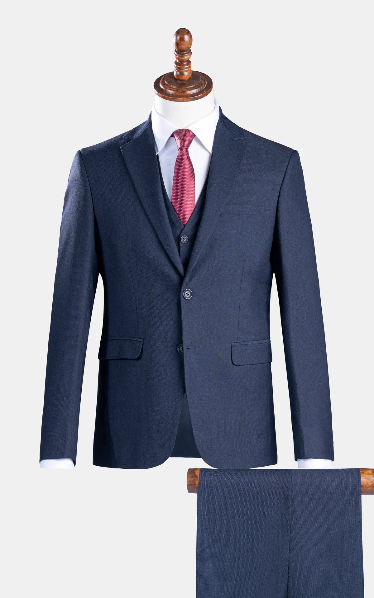 Dark navy slim-fit suit jacket with notch lapels and flap pockets, worn with red tie