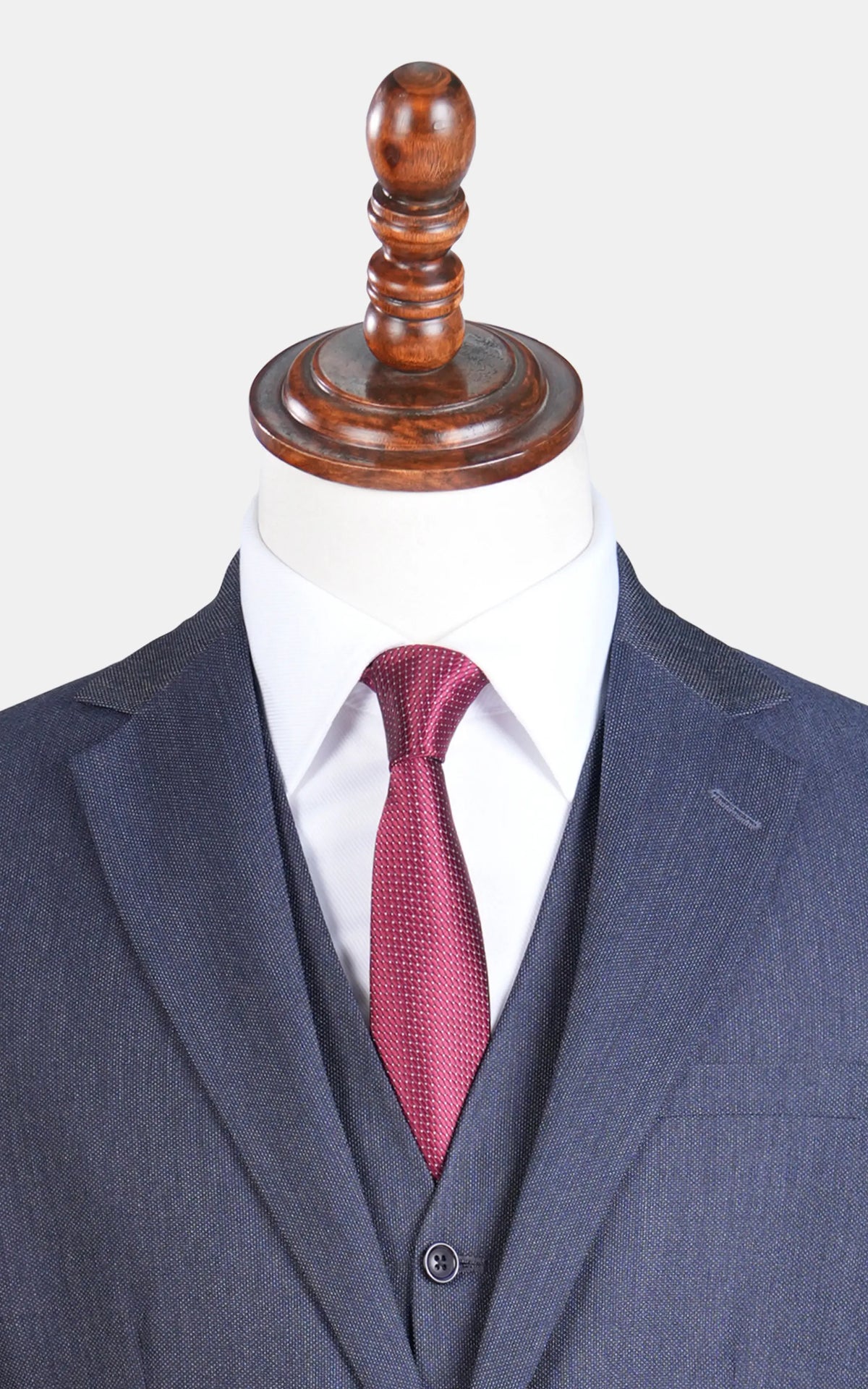 Teal blue suit jacket with notch lapel; red patterned tie and matching vest.