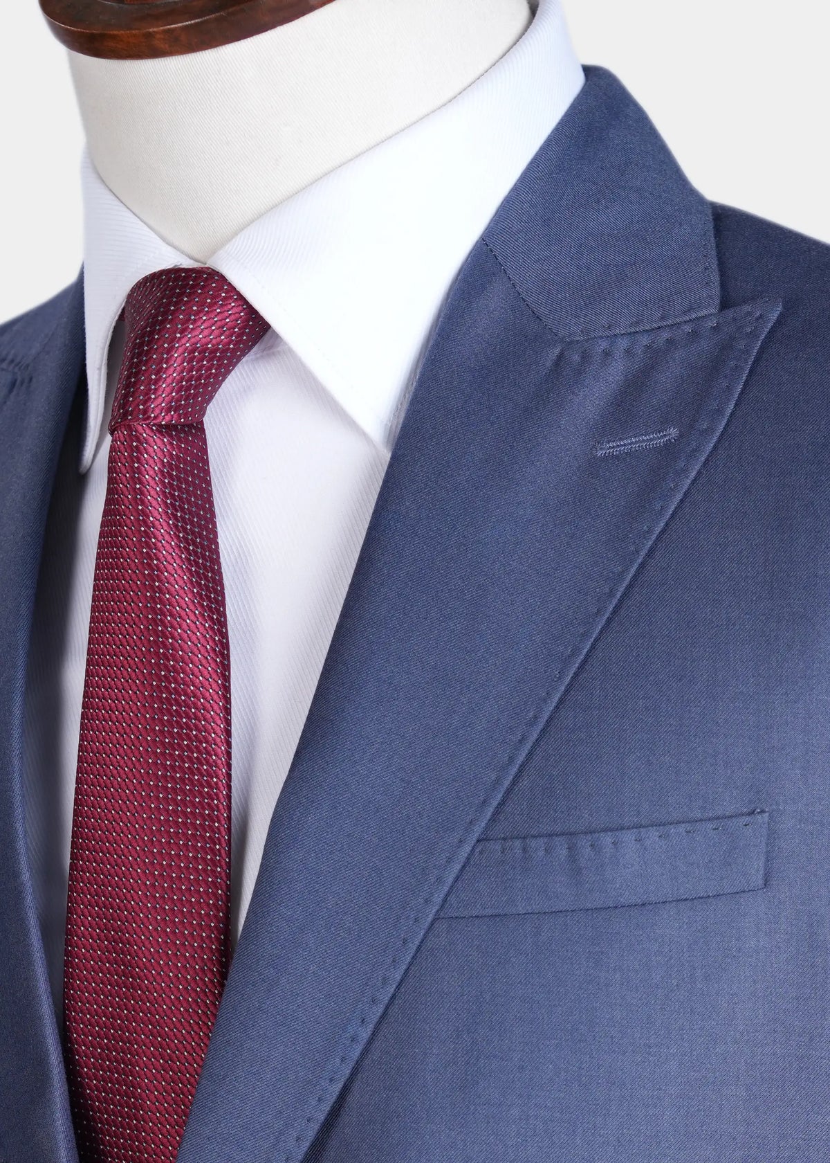 Bluish grey suit jacket lapel with red textured tie, close-up on collar.