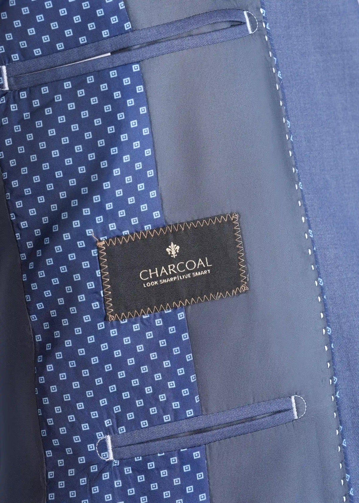 Bluish grey suit lining with charcoal label and stitched interior pocket, close-up.