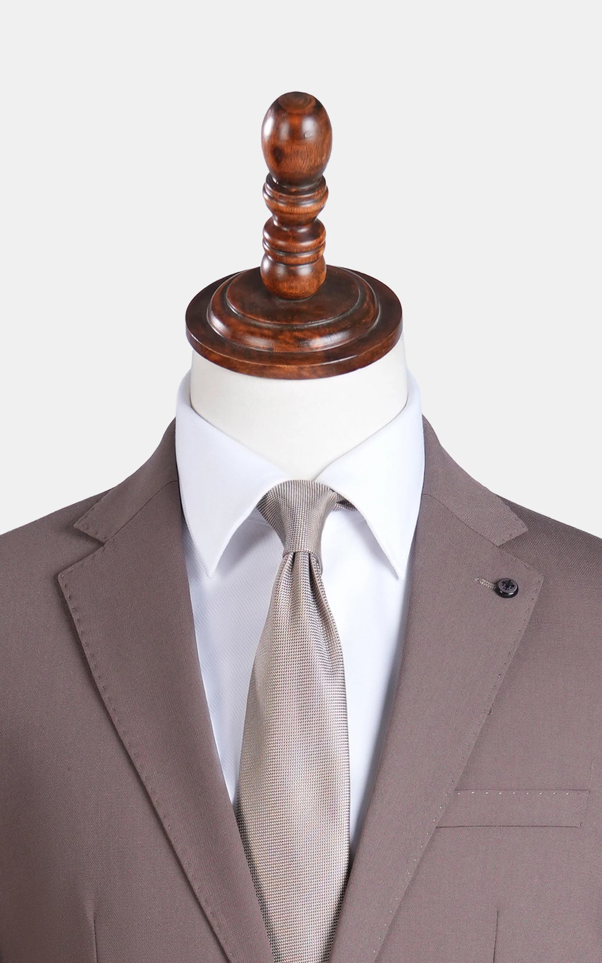 Brown suit jacket close-up with notch lapels, tie, and pocket flap details
