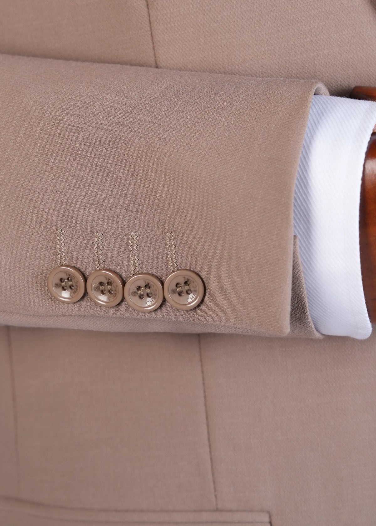 Light brown suit sleeve cuff with four buttons and white shirt cuff