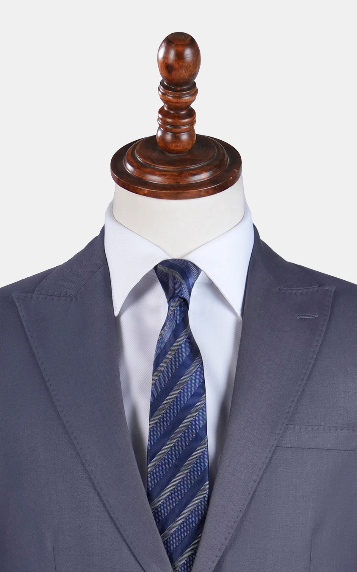 Slim-fit grey suit jacket close-up with blue striped tie and white dress shirt