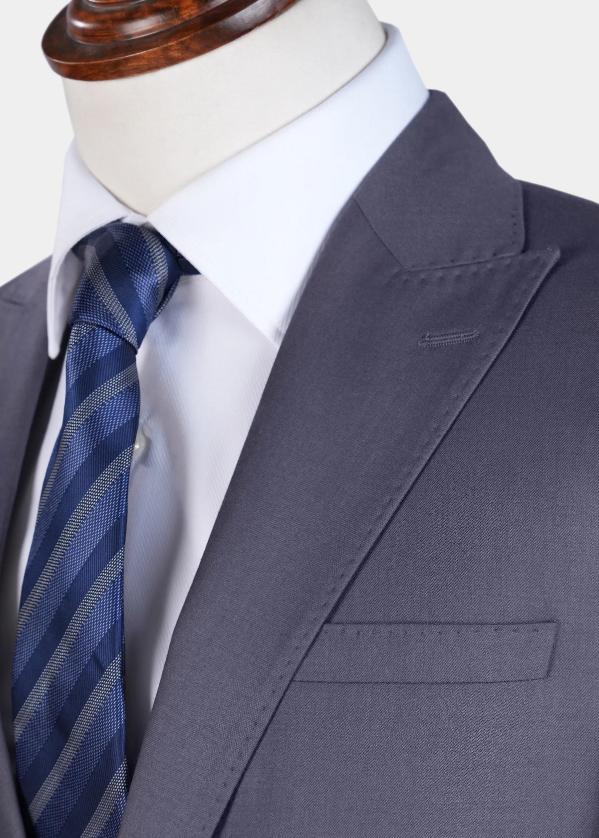 Grey suit jacket lapel and breast pocket with blue striped tie