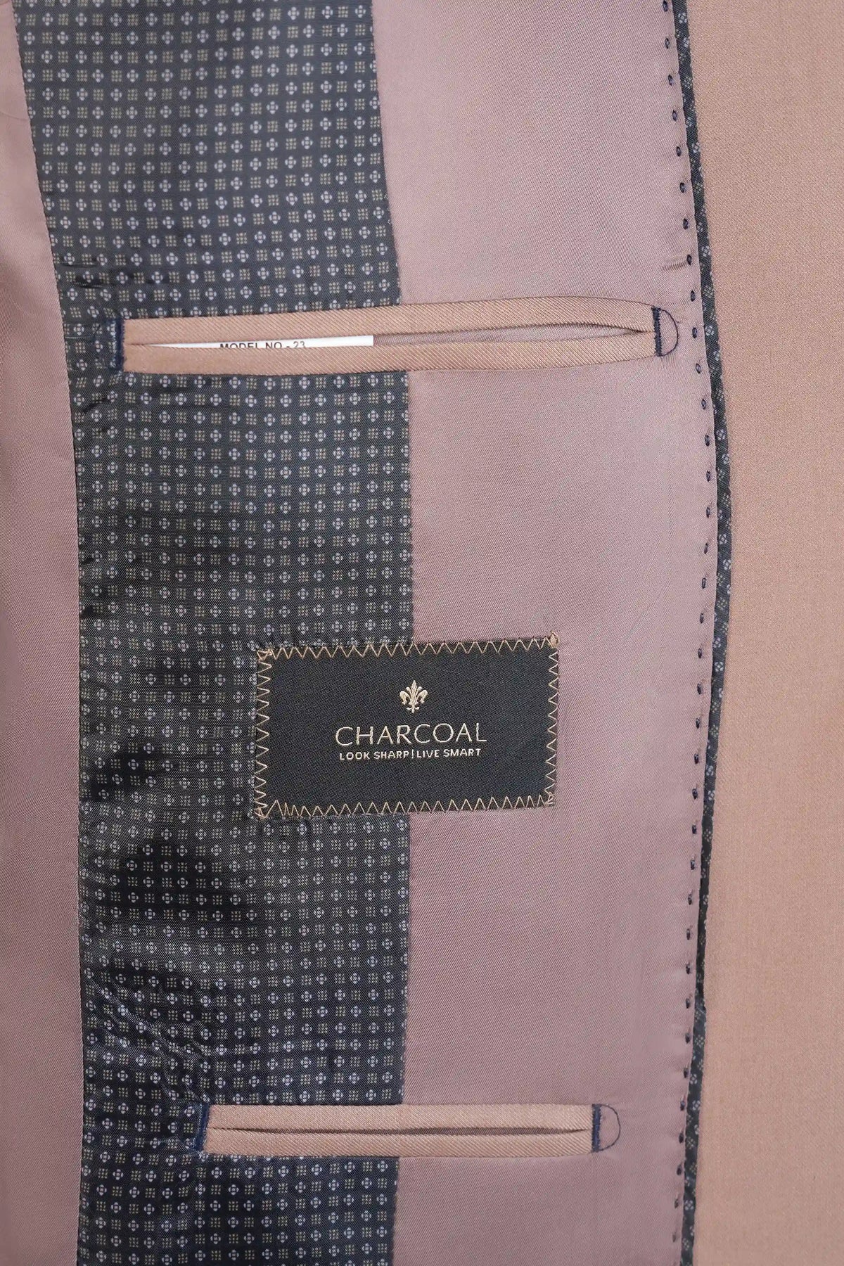Charcoal lining label inside light brown suit jacket with stitched pocket trim.