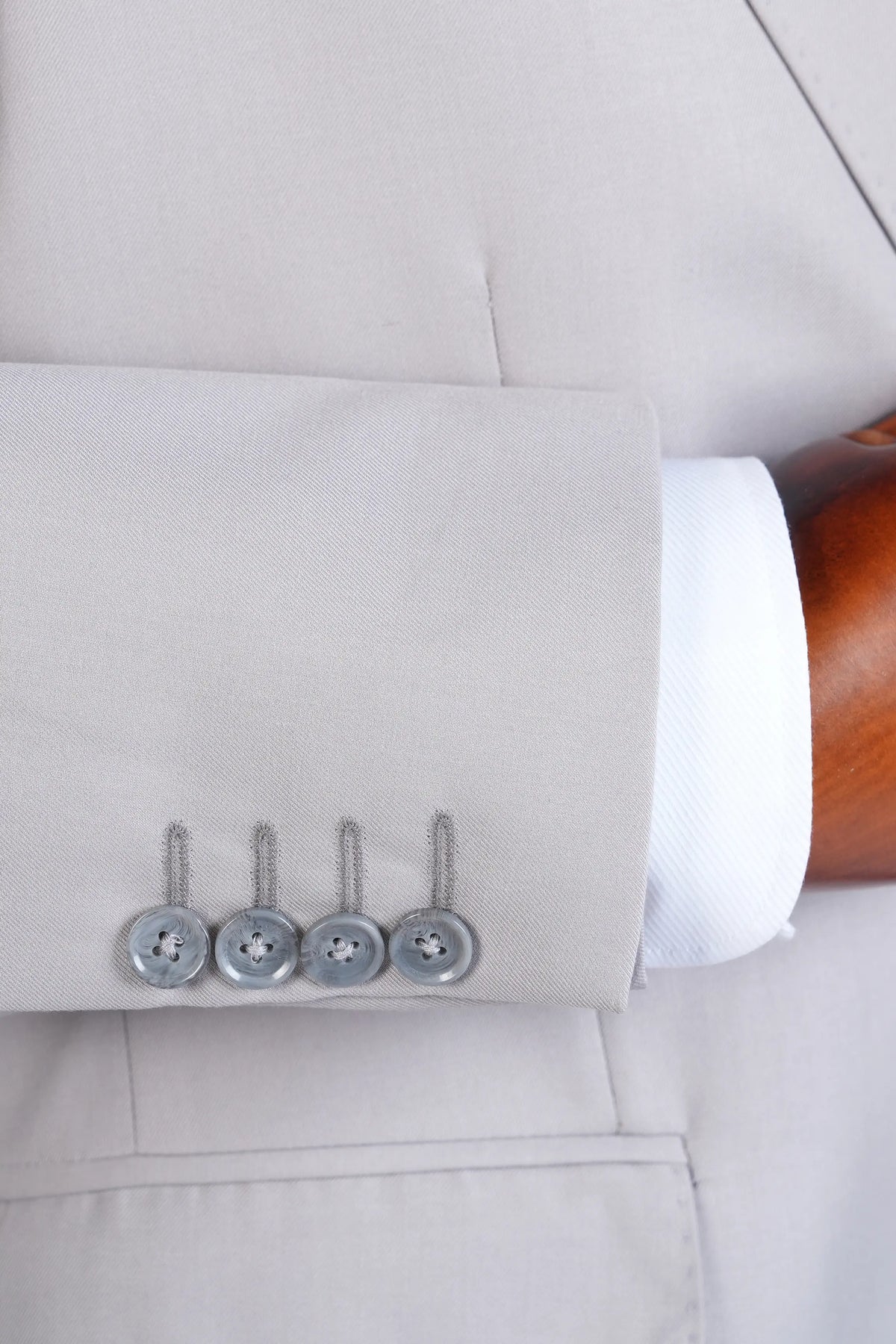 Stone gray jacket cuff with three-tone buttons and neat sleeve finish
