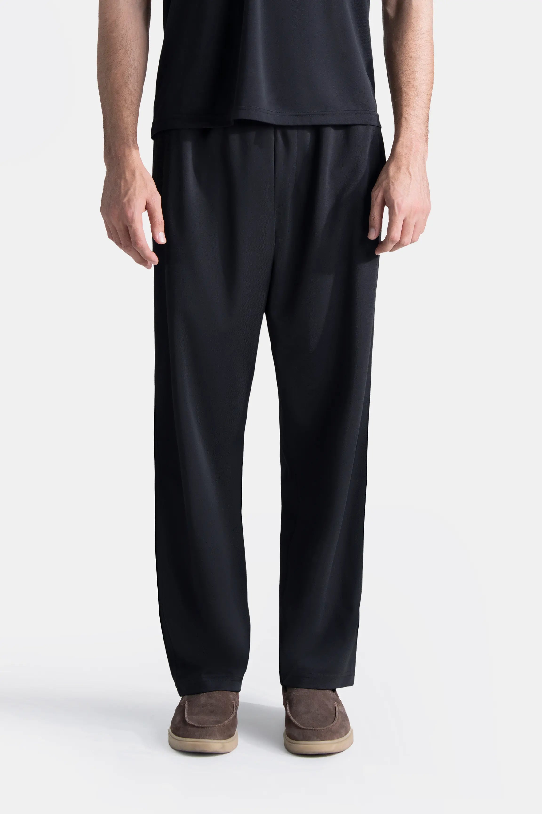 Black loose-fit trousers with elasticated waistband and tapered straight legs