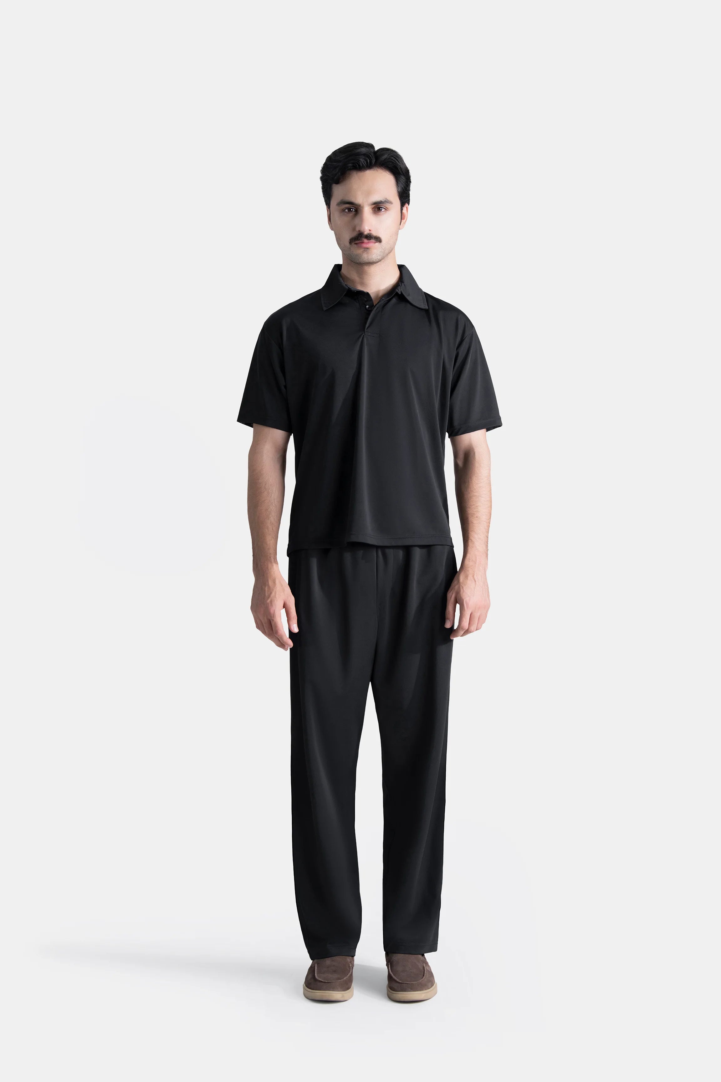 Loose-fit black polo shirt with short sleeves and two-button placket