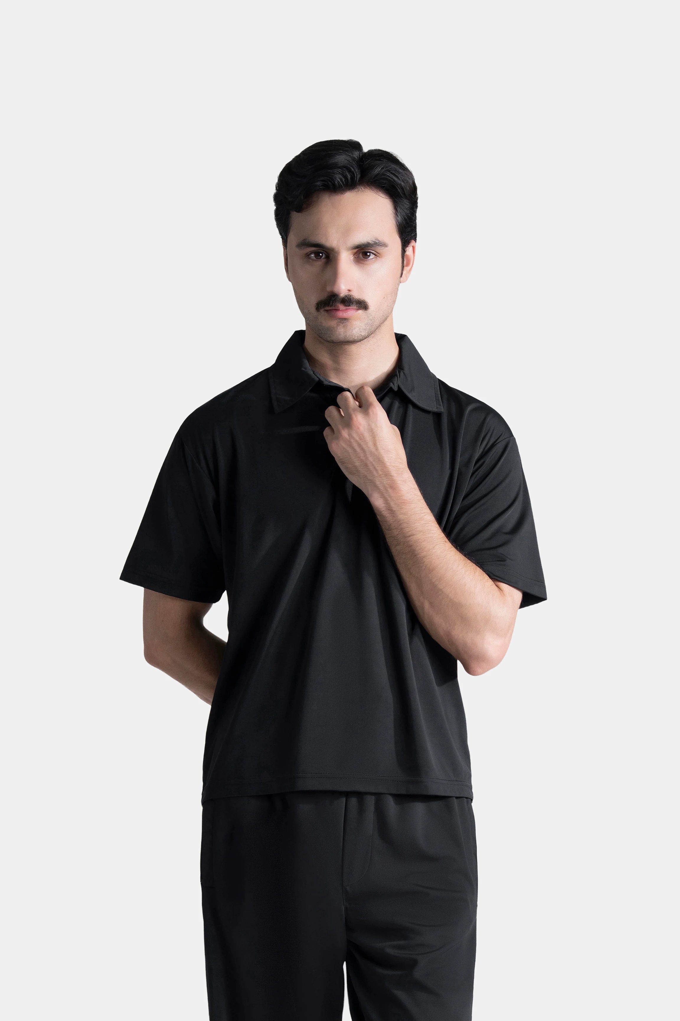 Black polo shirt with short sleeves, spread collar, and button placket