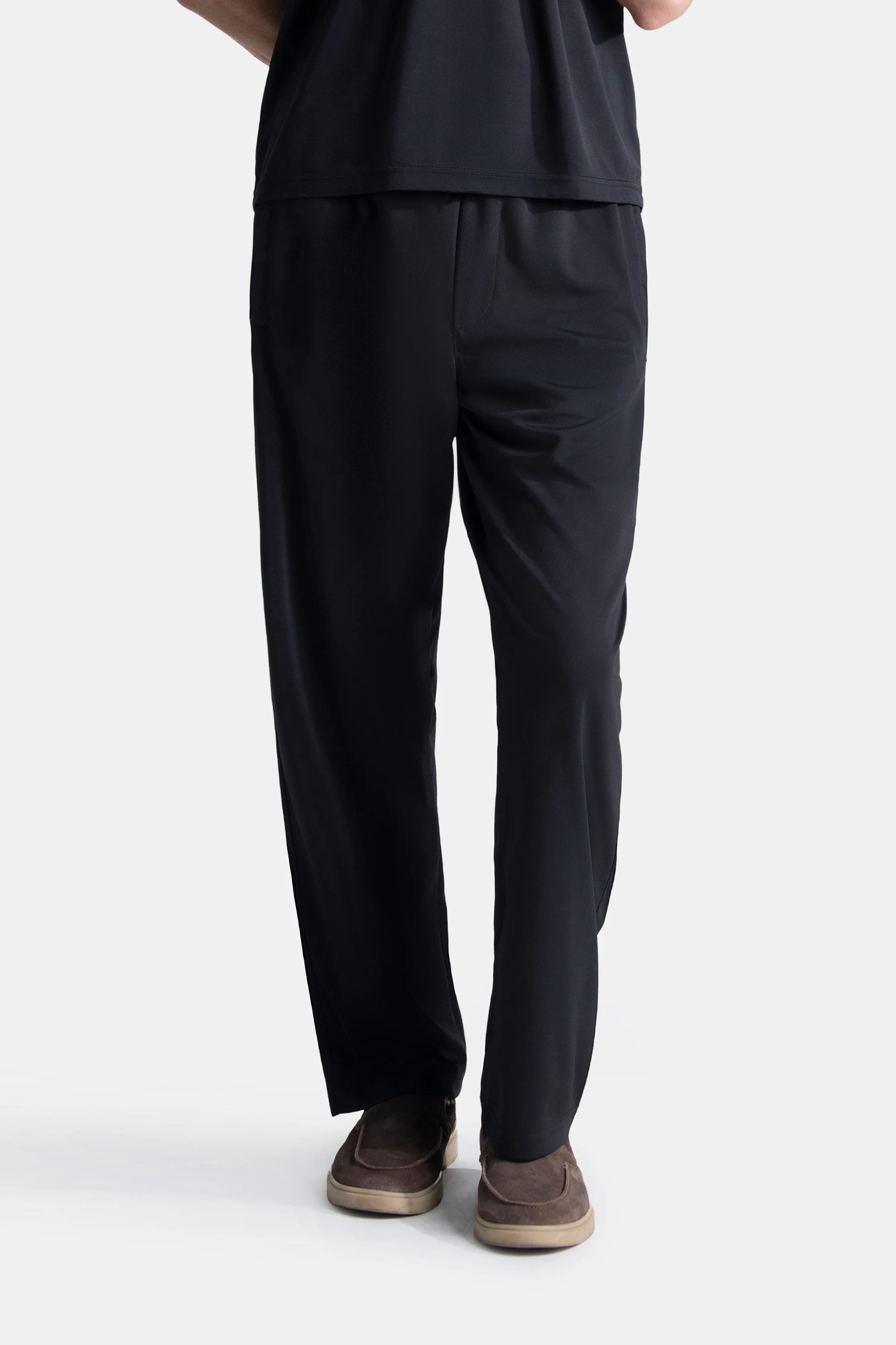 Black relaxed trousers with elasticated waist and straight, slightly tapered leg