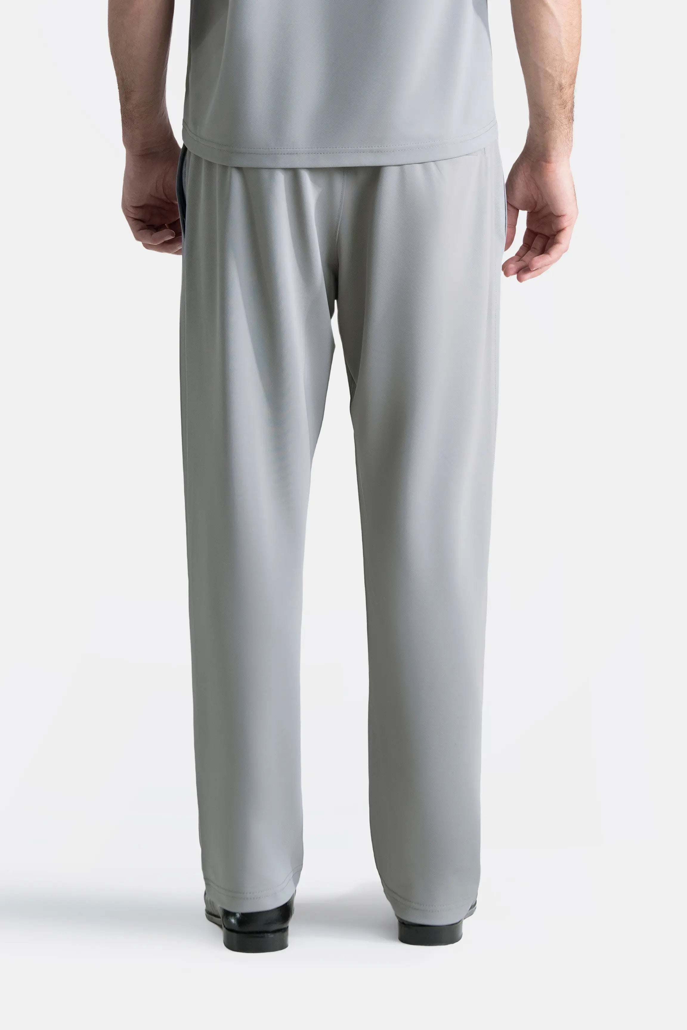Grey loose-fit trousers with elasticated waistband, front view, relaxed straight legs.