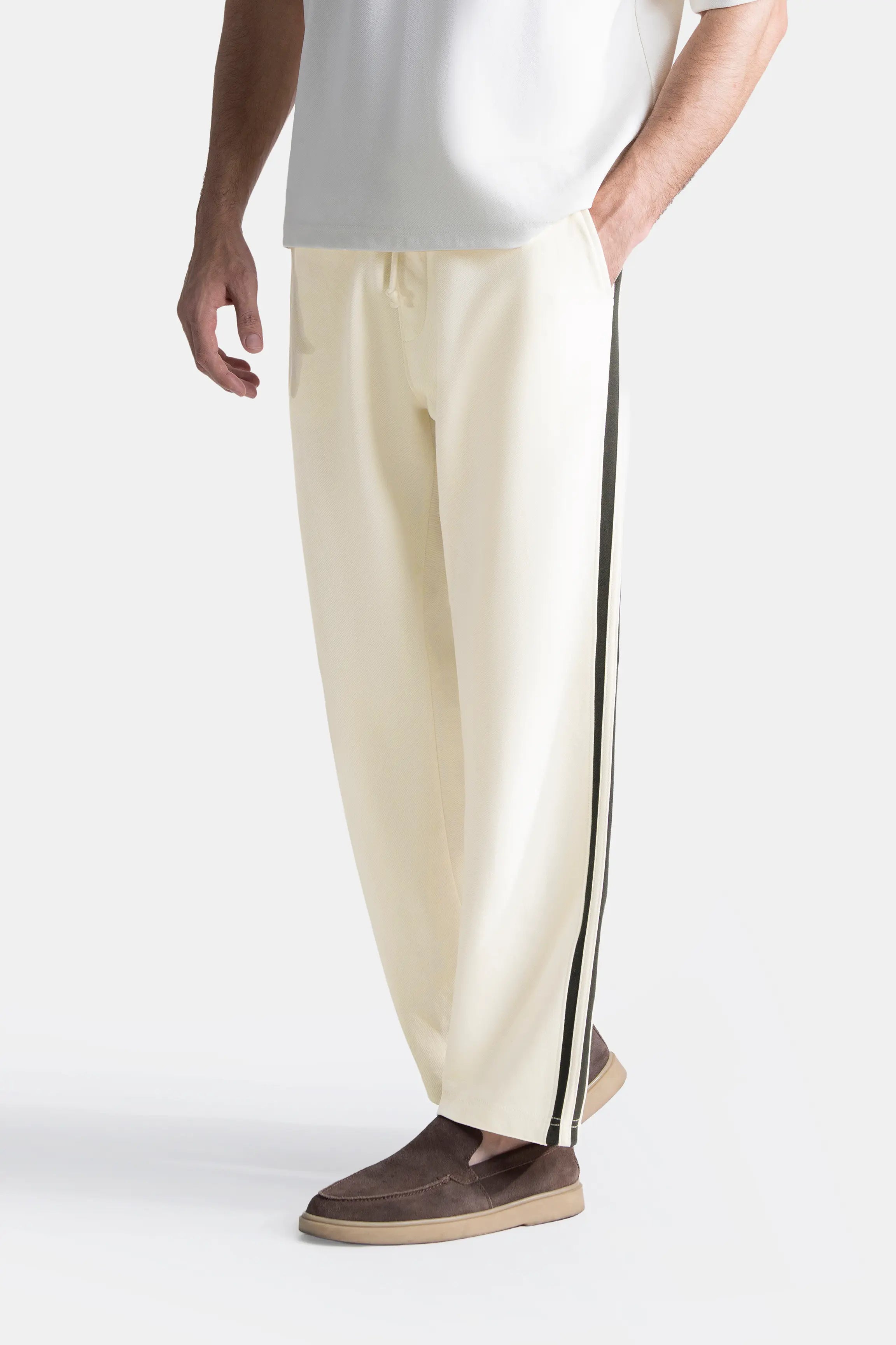 Off-white loose-fit trousers with black side stripe and tapered hem