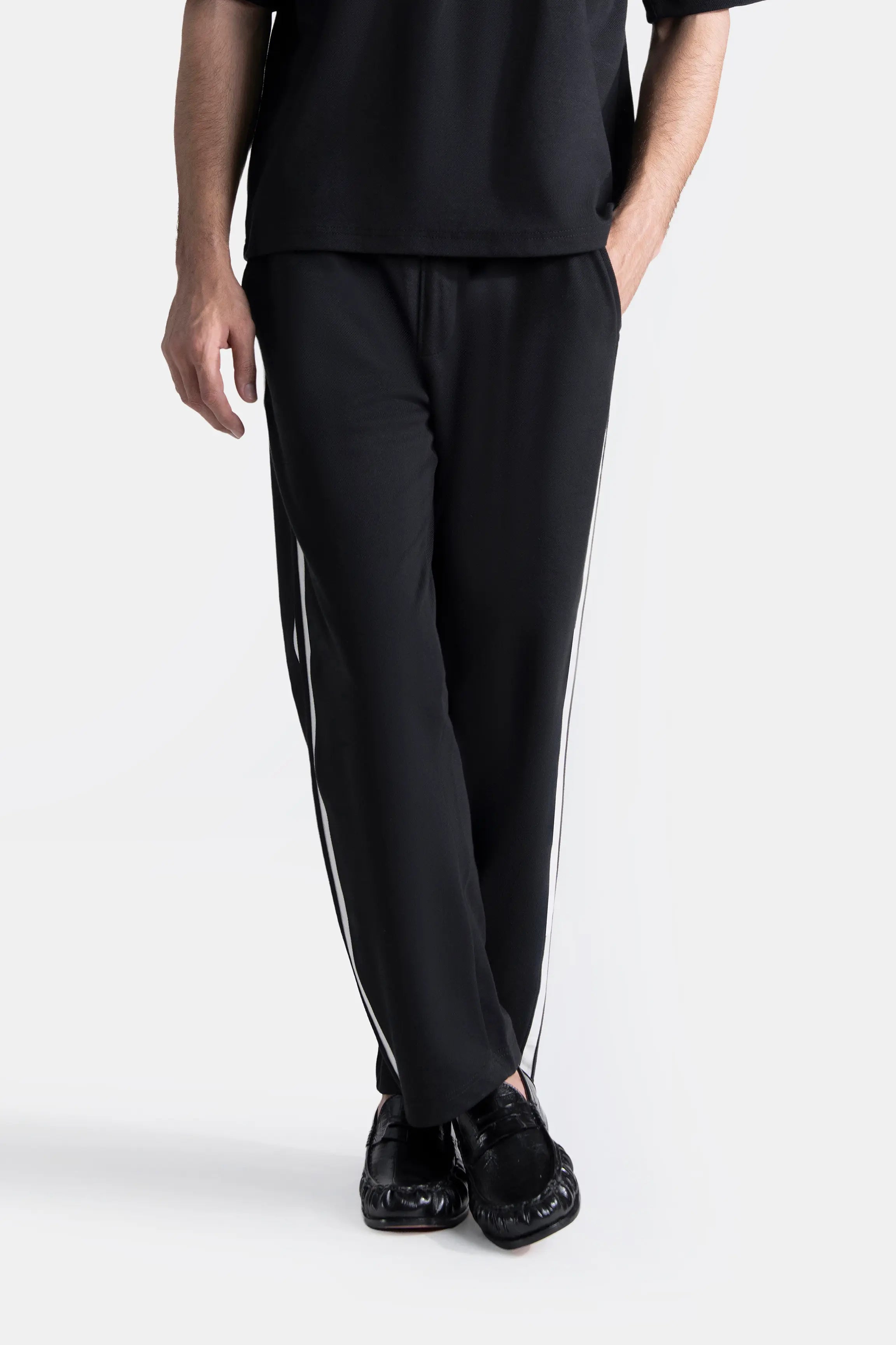Black loose-fit trousers with contrast side stripe and ankle hem