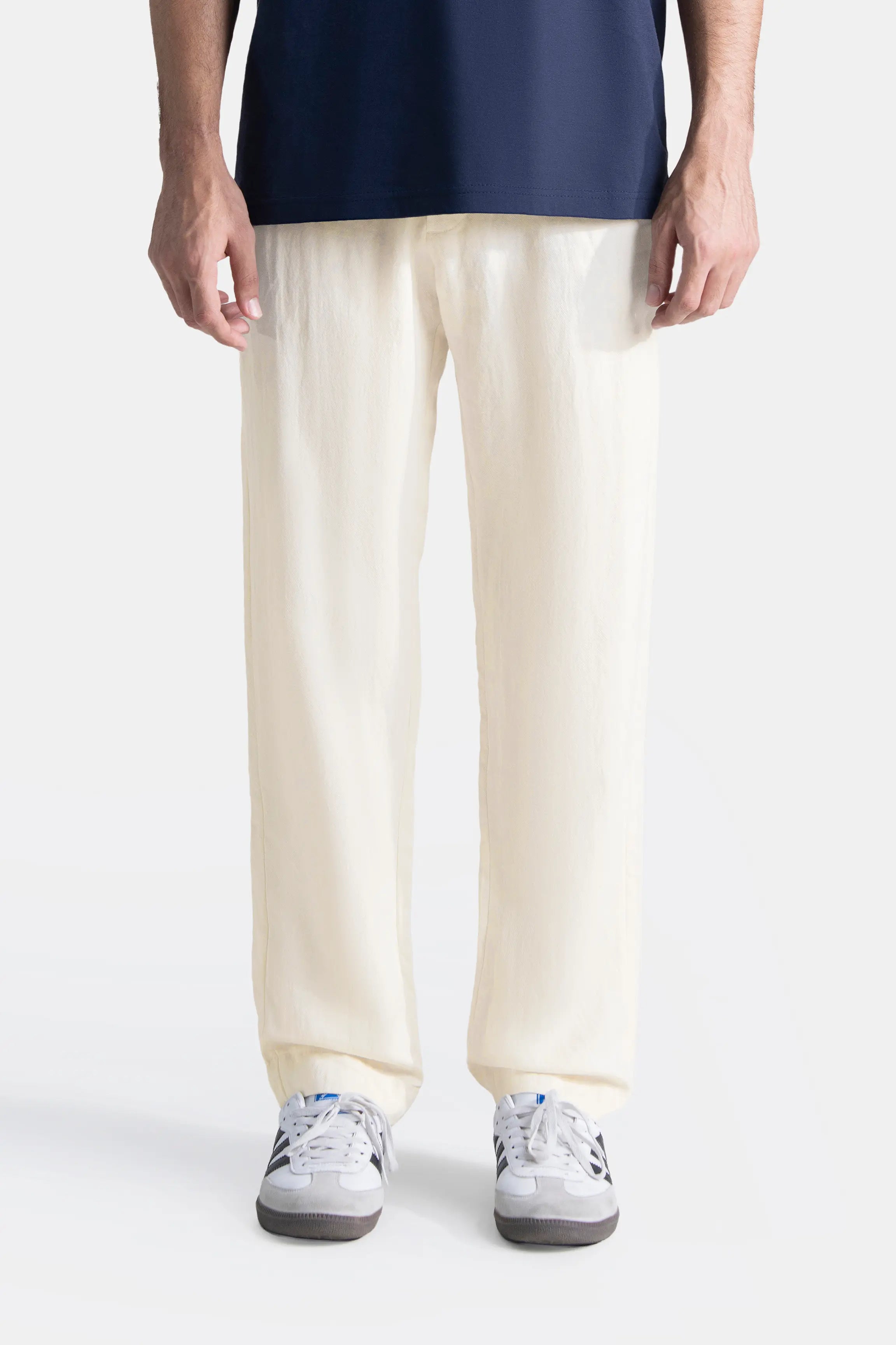Off-white straight-leg pants on model, front view with sneakers
