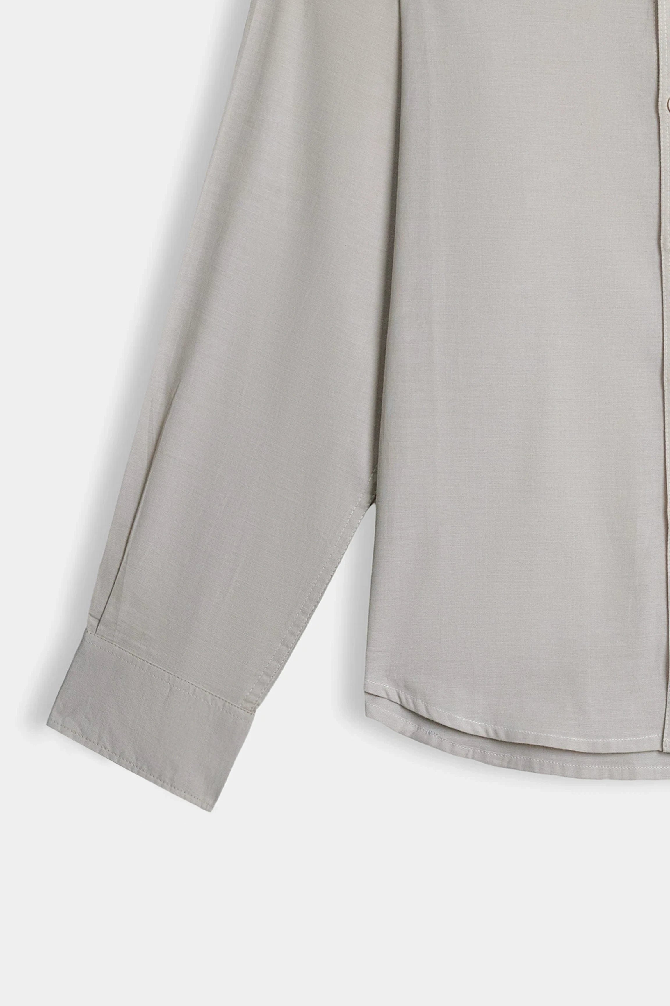 Khaki button-down shirt showing sleeve and straight hem.