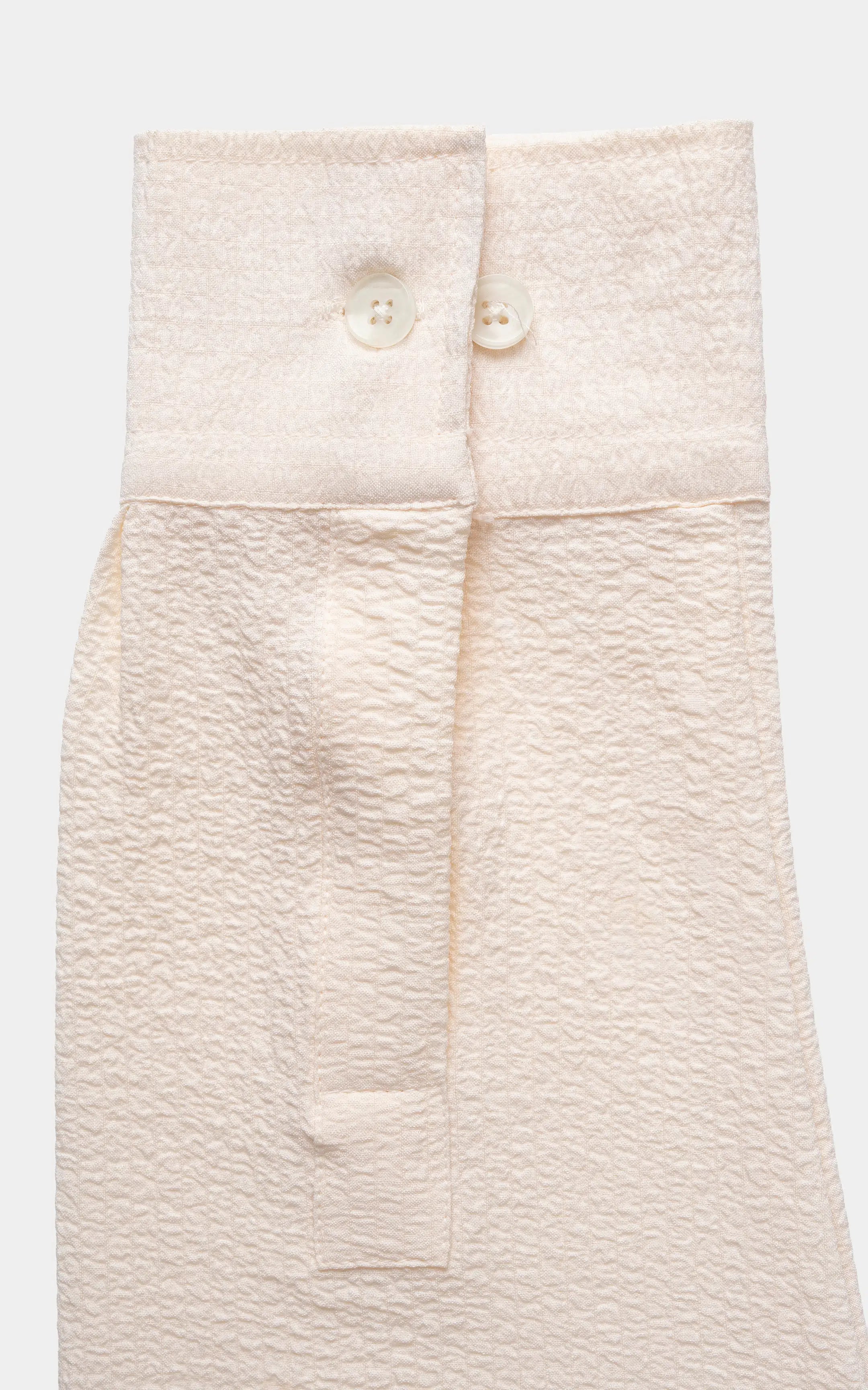 Off-white relaxed-fit shirt laid flat, showing top buttons and placket