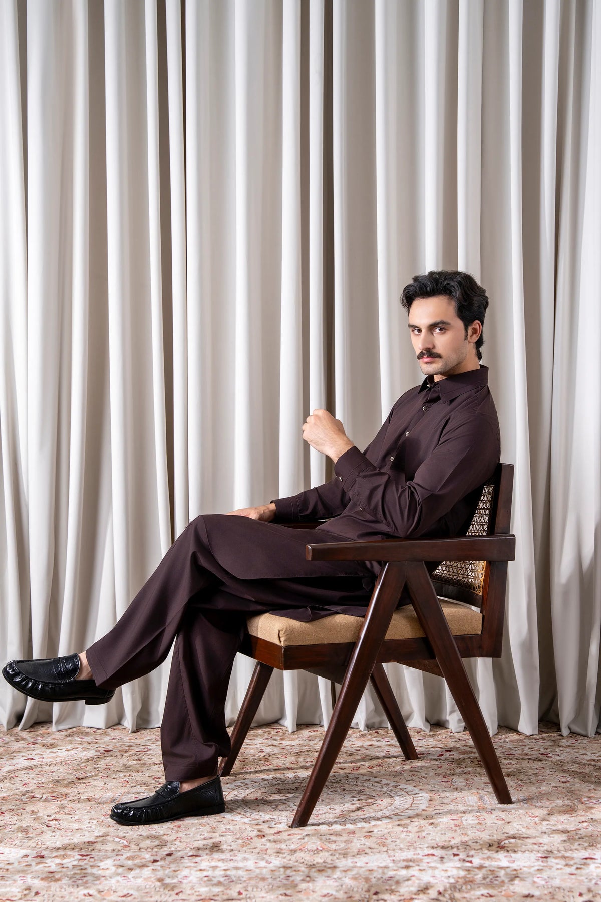 Men's maroon kameez shalwar set sitting pose, long tunic with matching straight pants