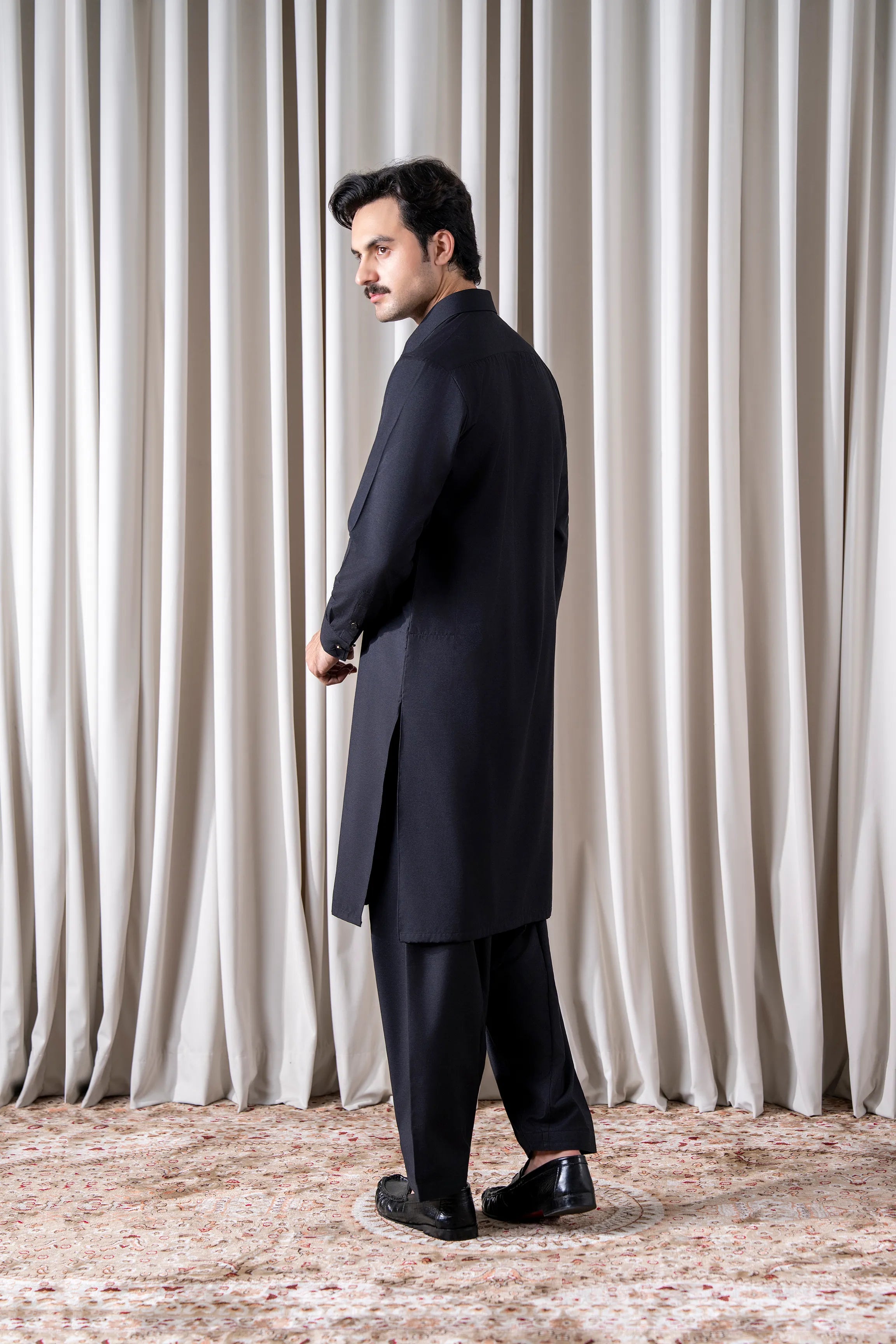 Black textured kameez shalwar set shown from the side, long tunic and matching shalwar
