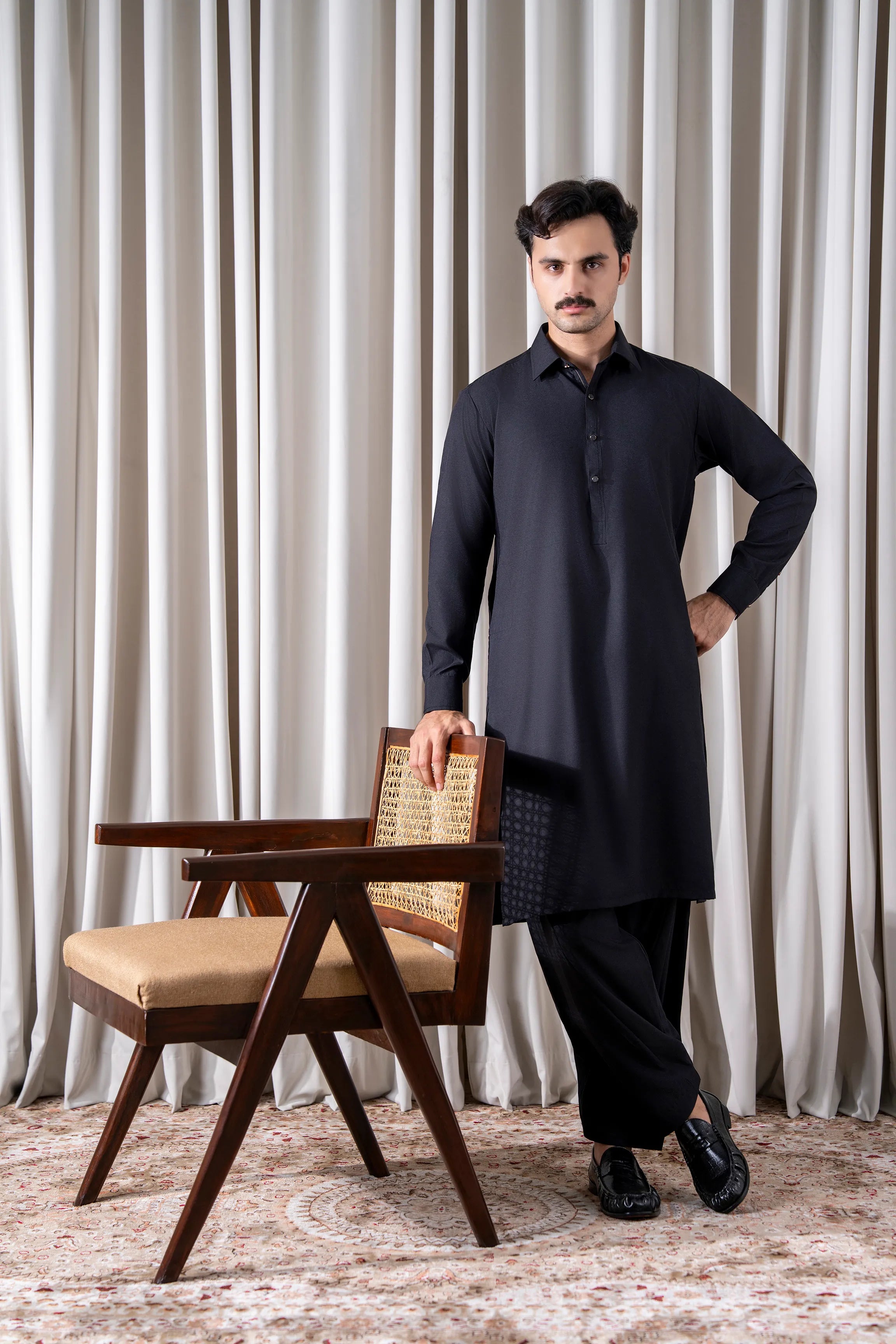 Black textured kameez shalwar set, long collared tunic with buttons, worn with black shalwar