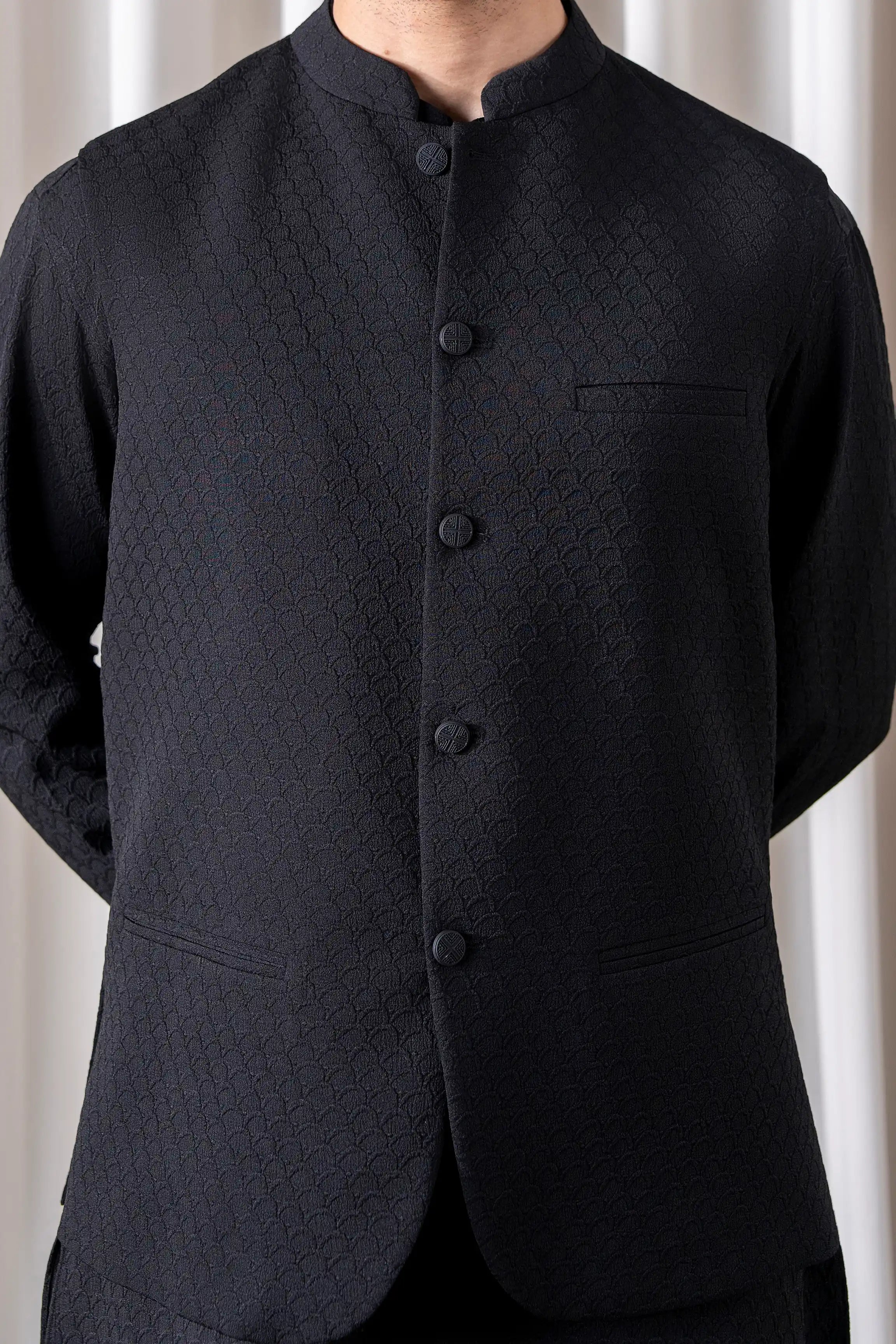 Black textured waistcoat with button placket and chest pocket, standing view
