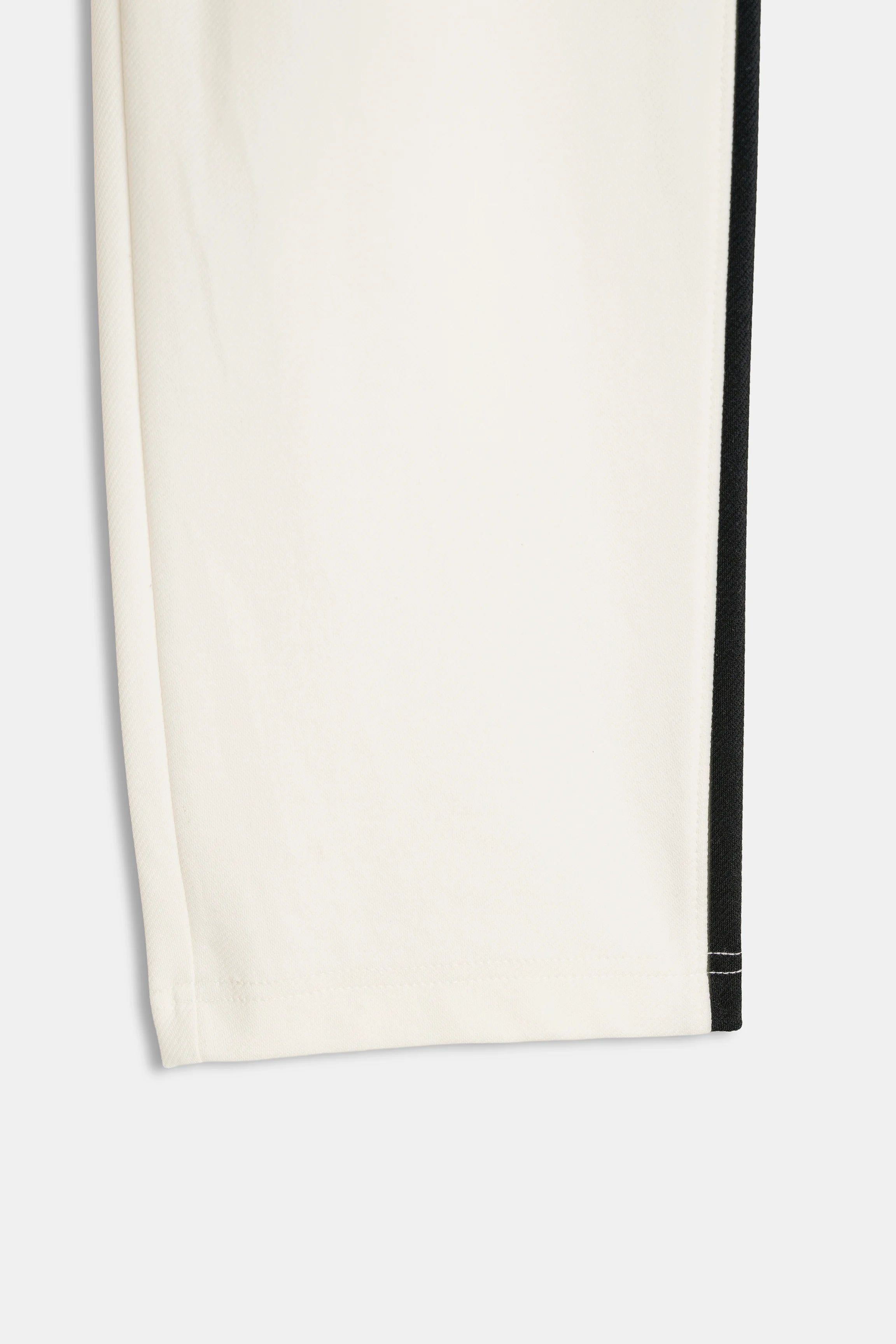 Off-white trouser leg with black side stripe at hem