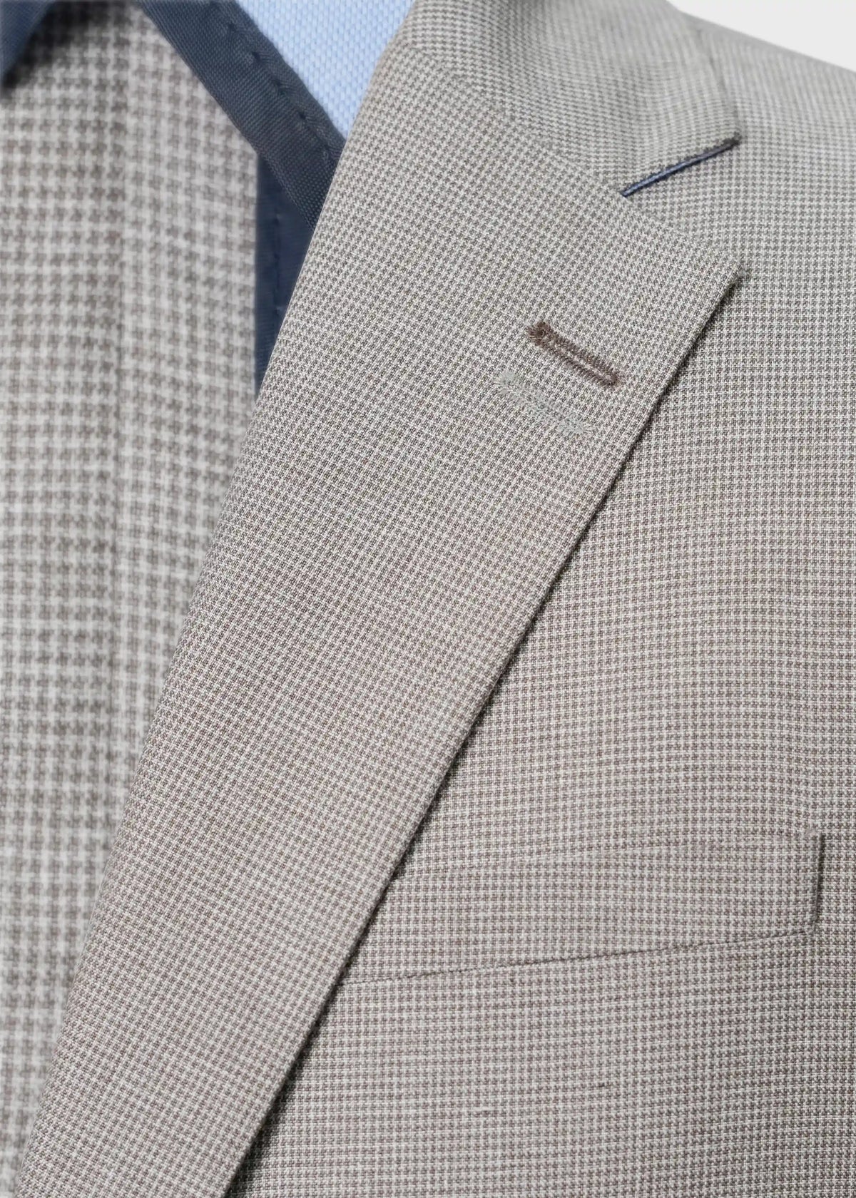 Khaki check coat close-up of lapel, welt pocket, and front buttons