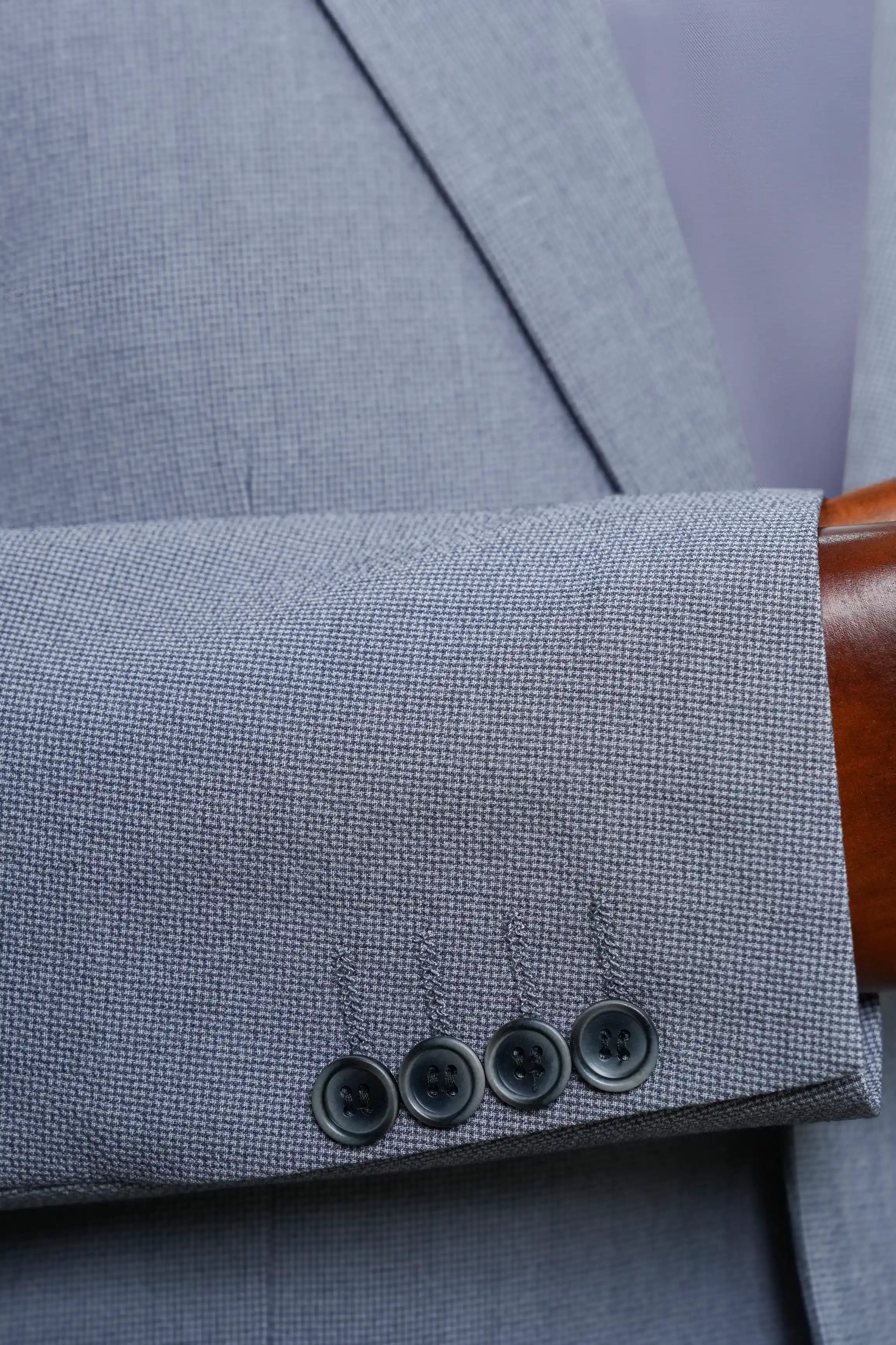 Grey casual coat cuff detail with three dark buttons on sleeve hem