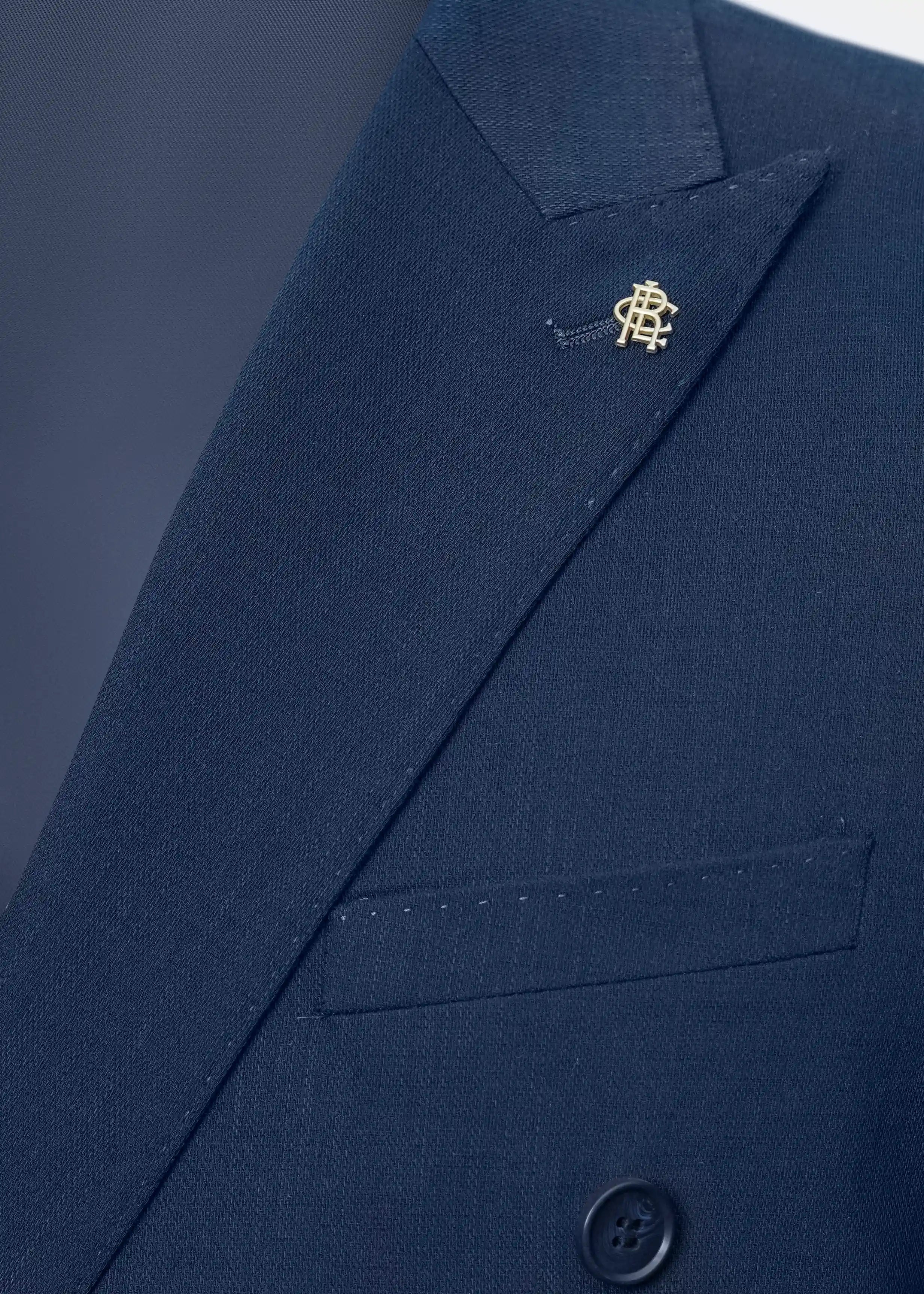 Navy casual coat lapel with decorative pin and buttoned chest pocket