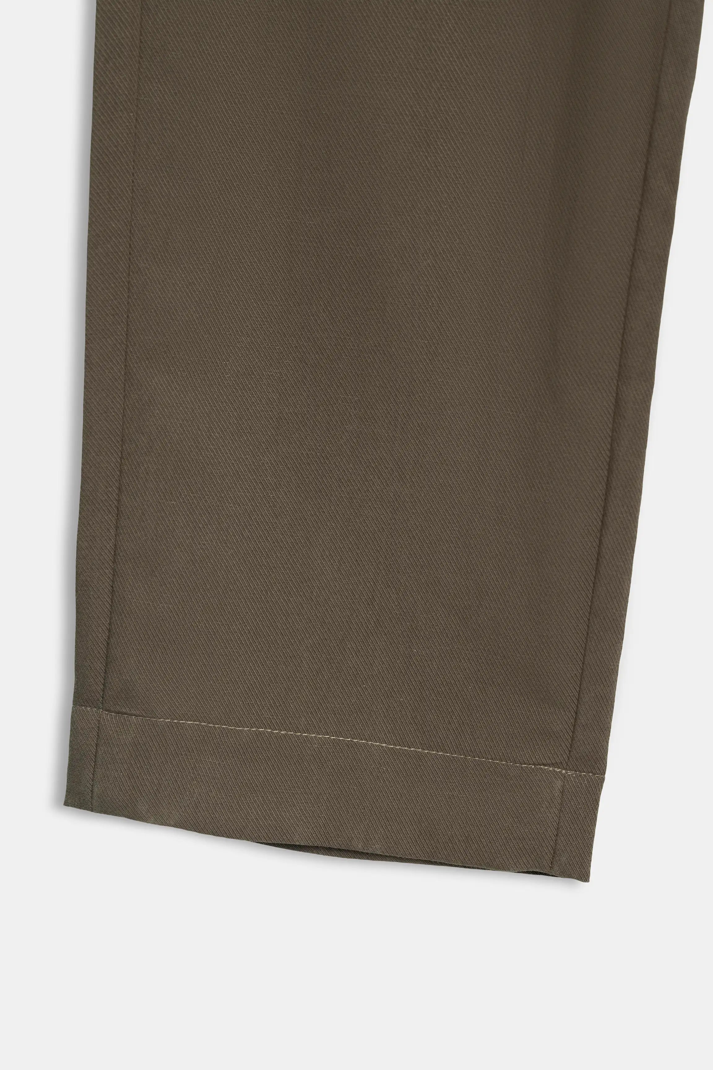 Brown pant leg with straight hem and stitched seam near the cuff
