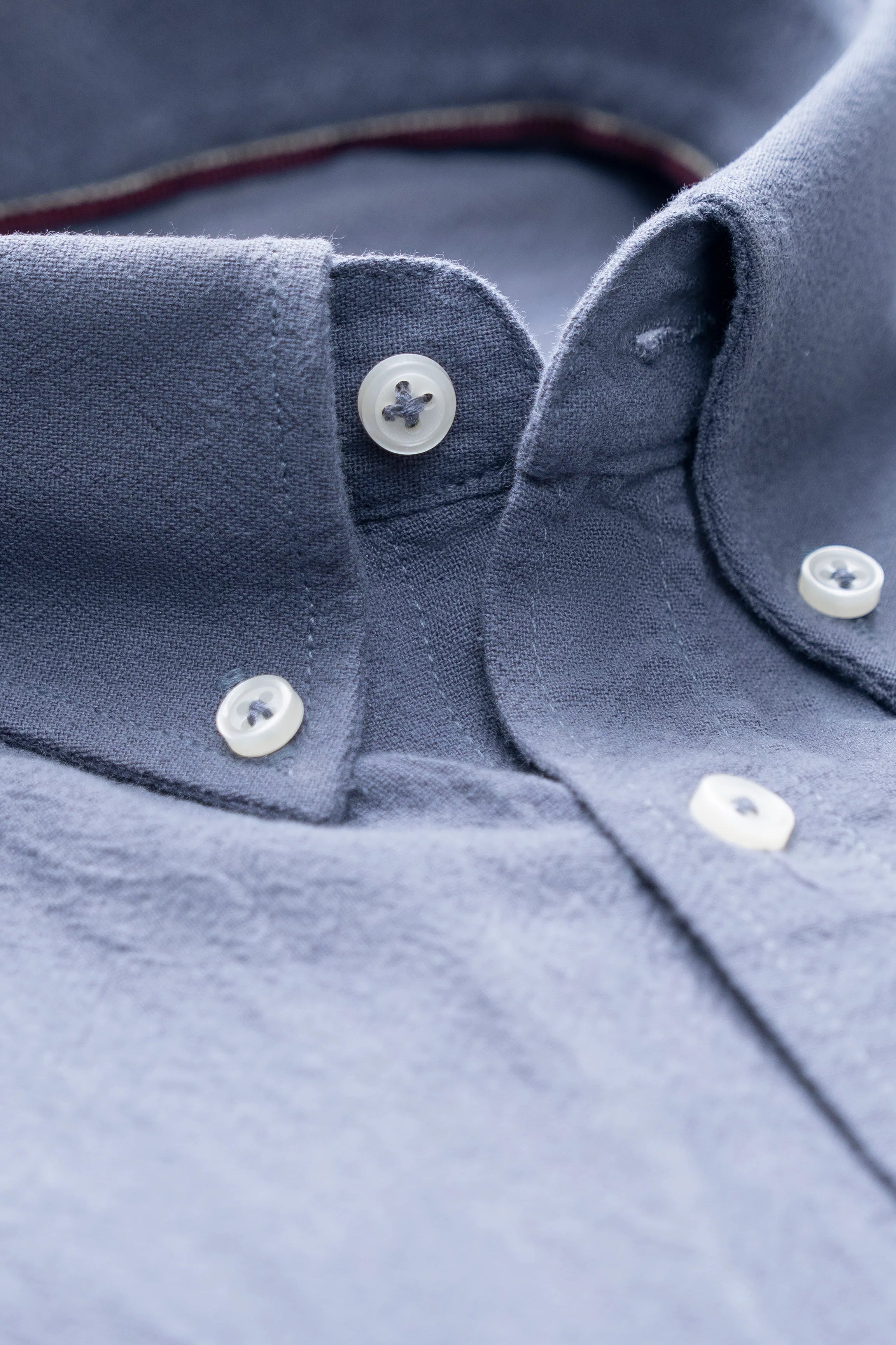 Grey shirt collar with visible buttons and inner placket, close-up