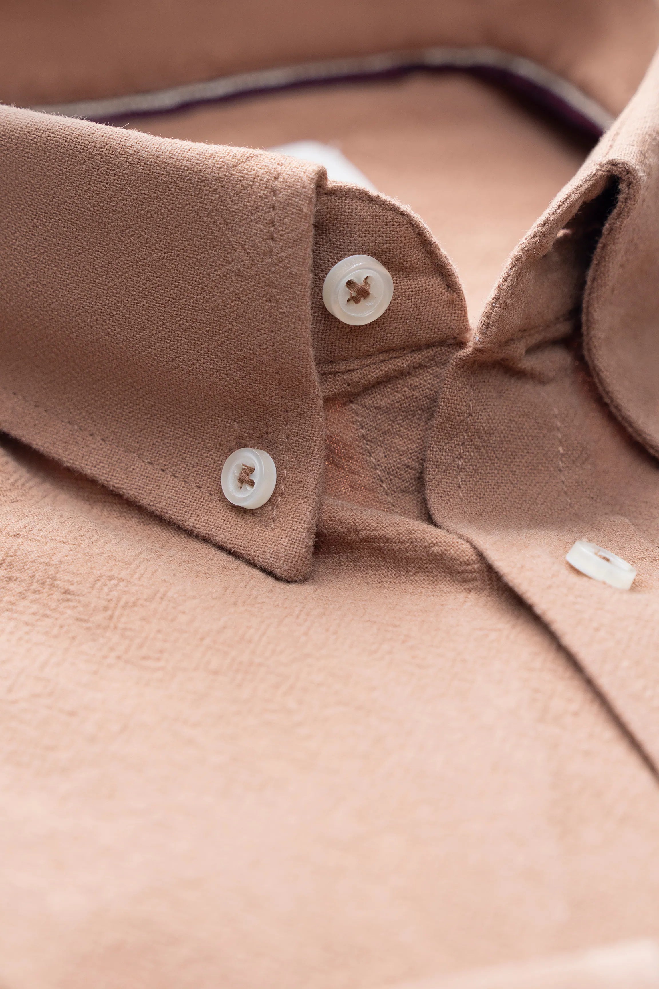 Brown dress shirt close-up of spread collar and button placket with fabric texture