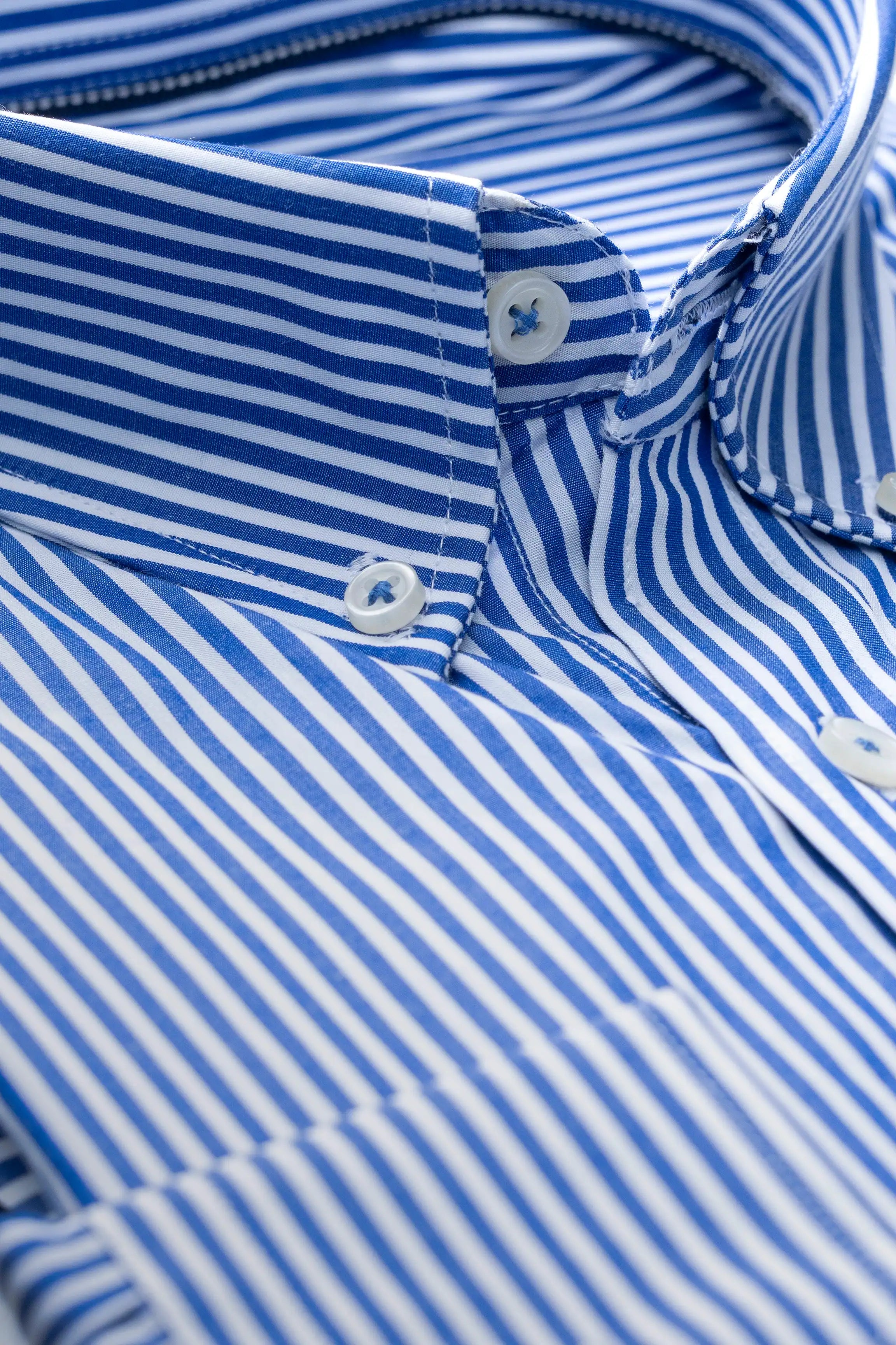 Blue and white striped dress shirt close-up of buttoned cuffs and collar