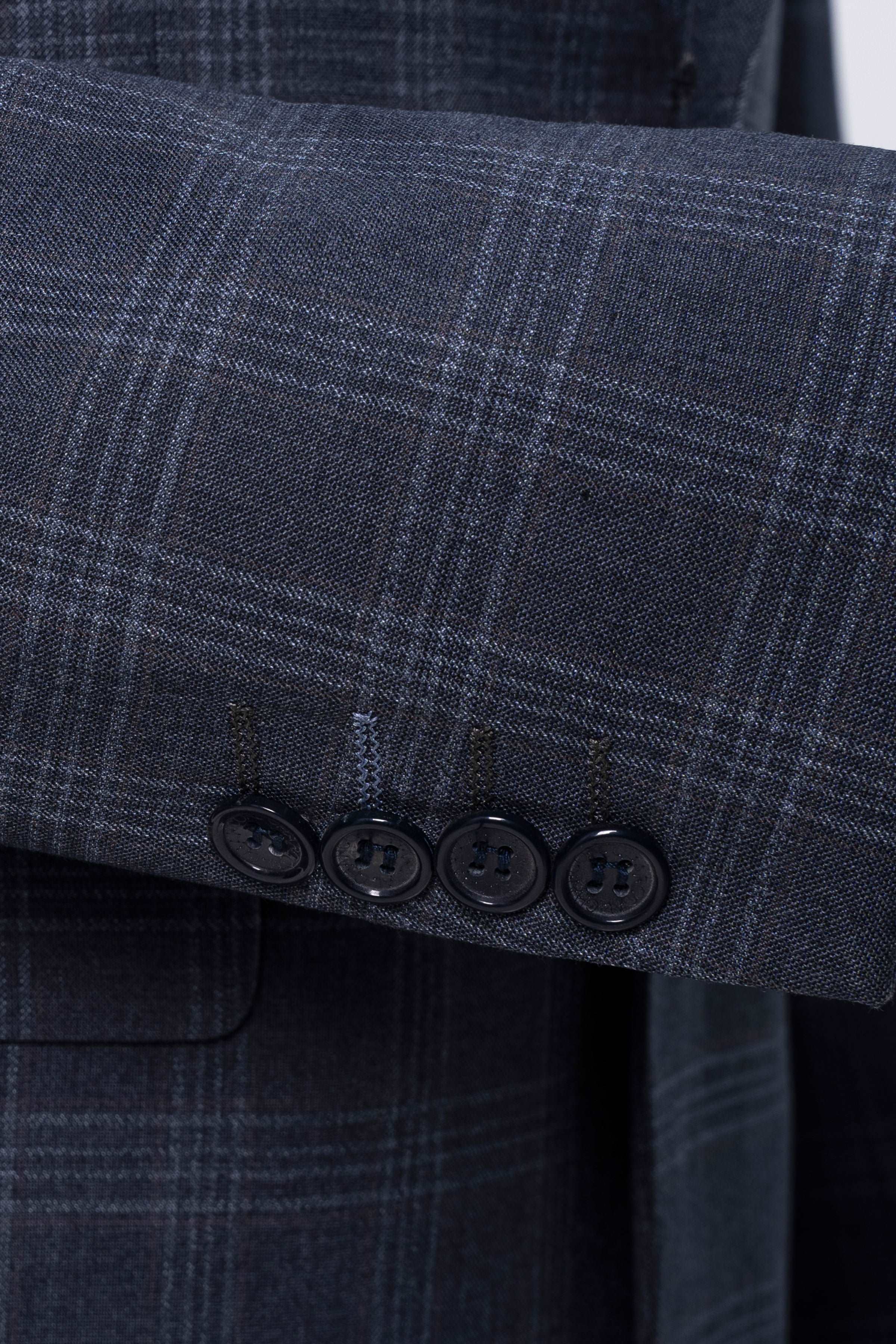 Blue-gray plaid suit jacket sleeve with four-button cuff detail
