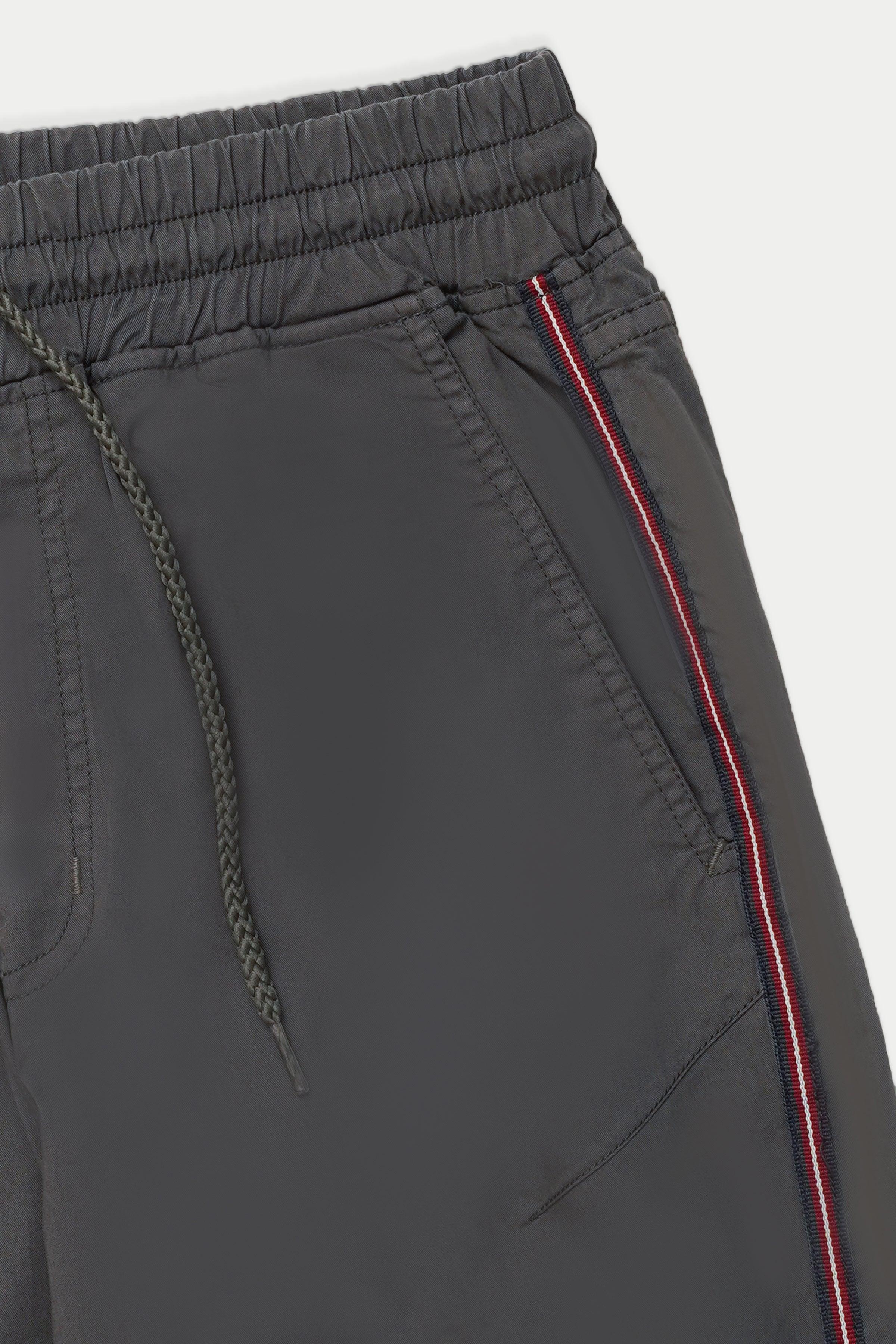 Dark grey jogger trousers close-up of drawstring pocket and red side stripe