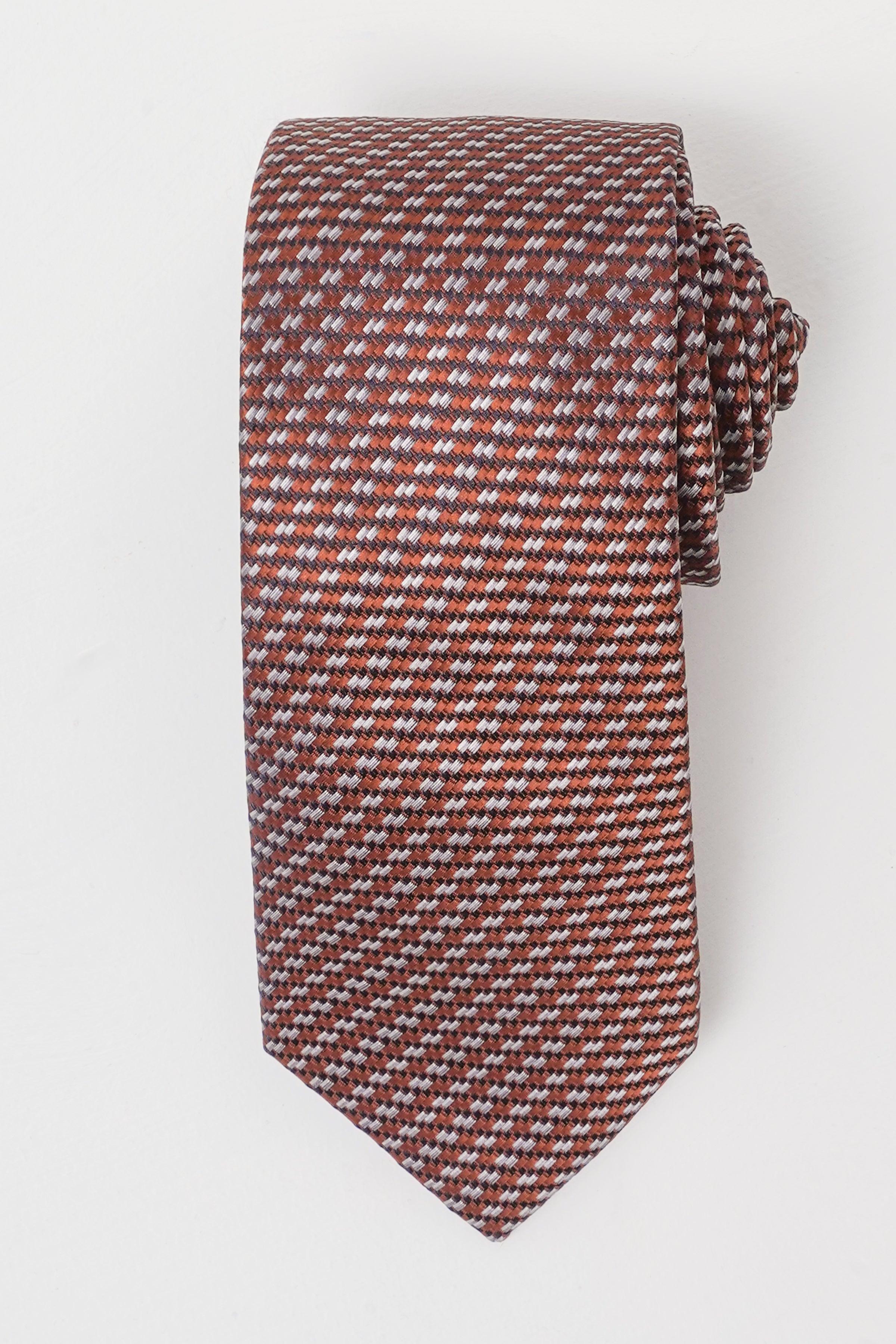 Maroon patterned silk tie with narrow end and stitched fold, small geometric weave.