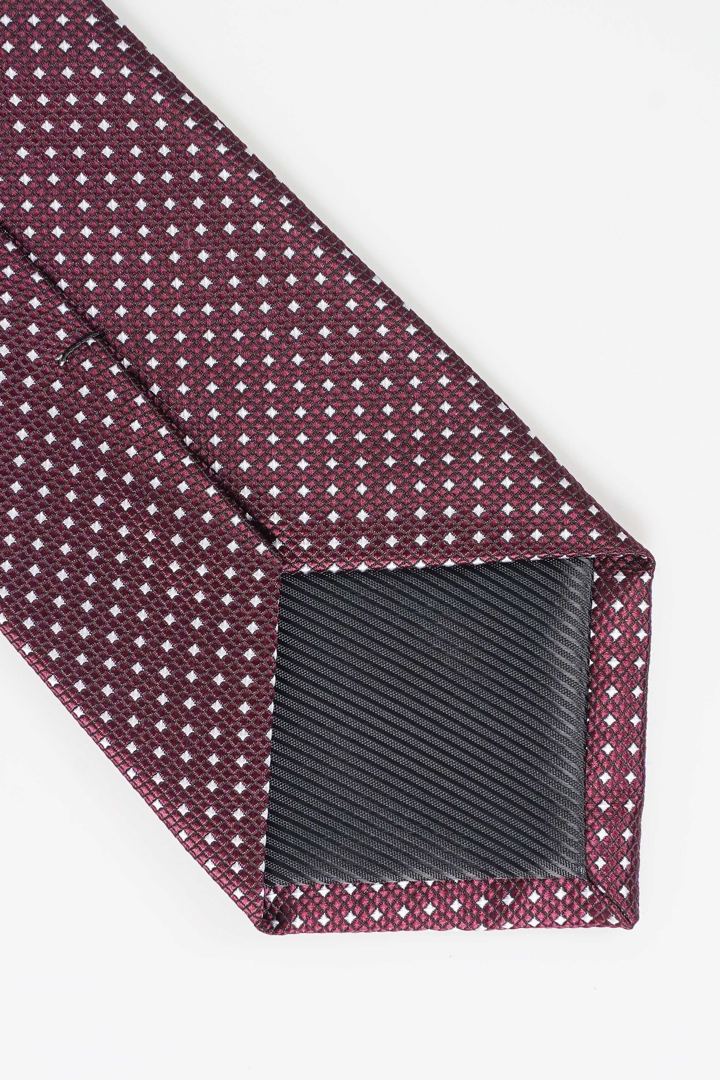Poly silk tie close-up of maroon fabric with repeating white square dots