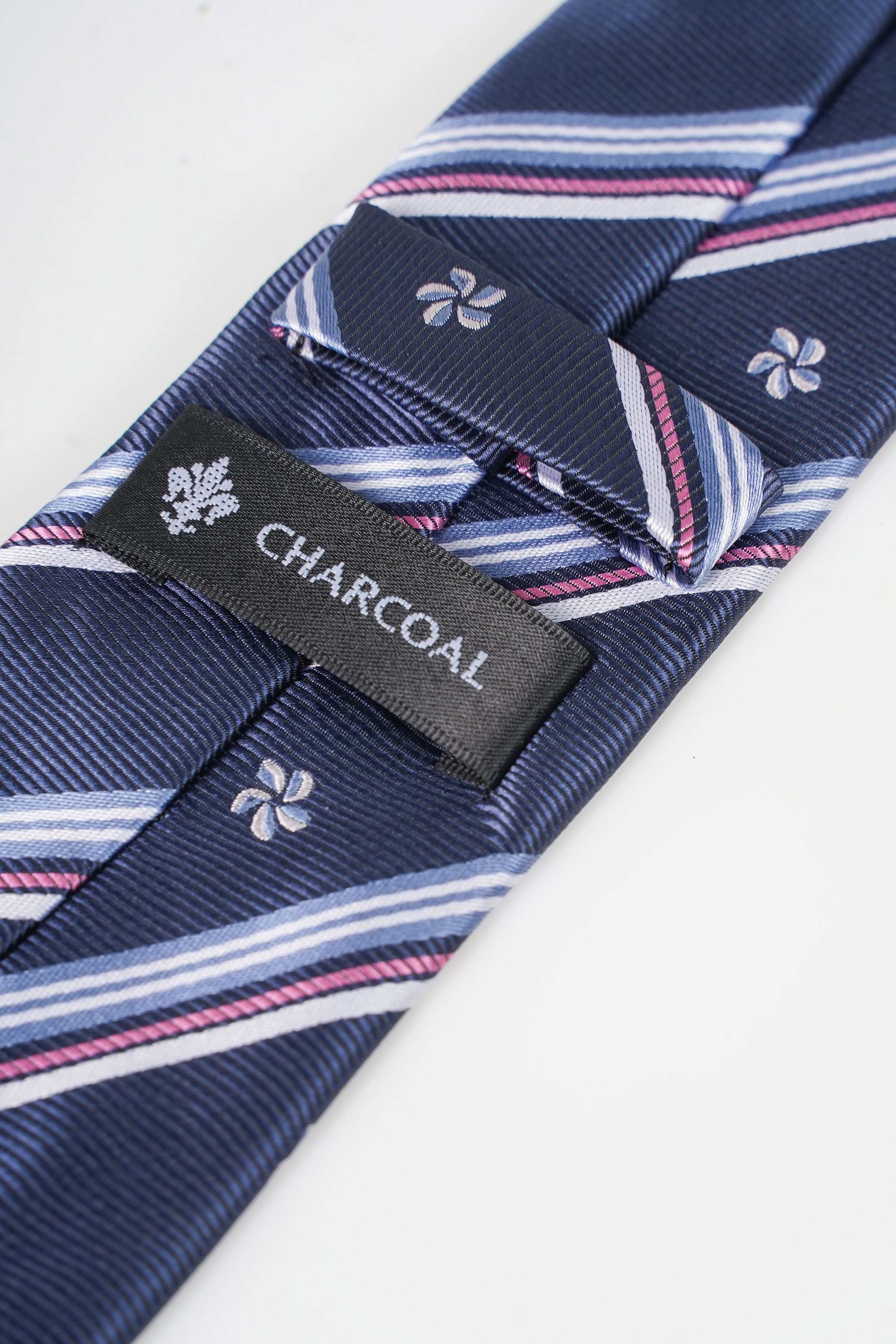 Navy poly silk necktie with stripe bands, clover motifs, and CHARCOAL label