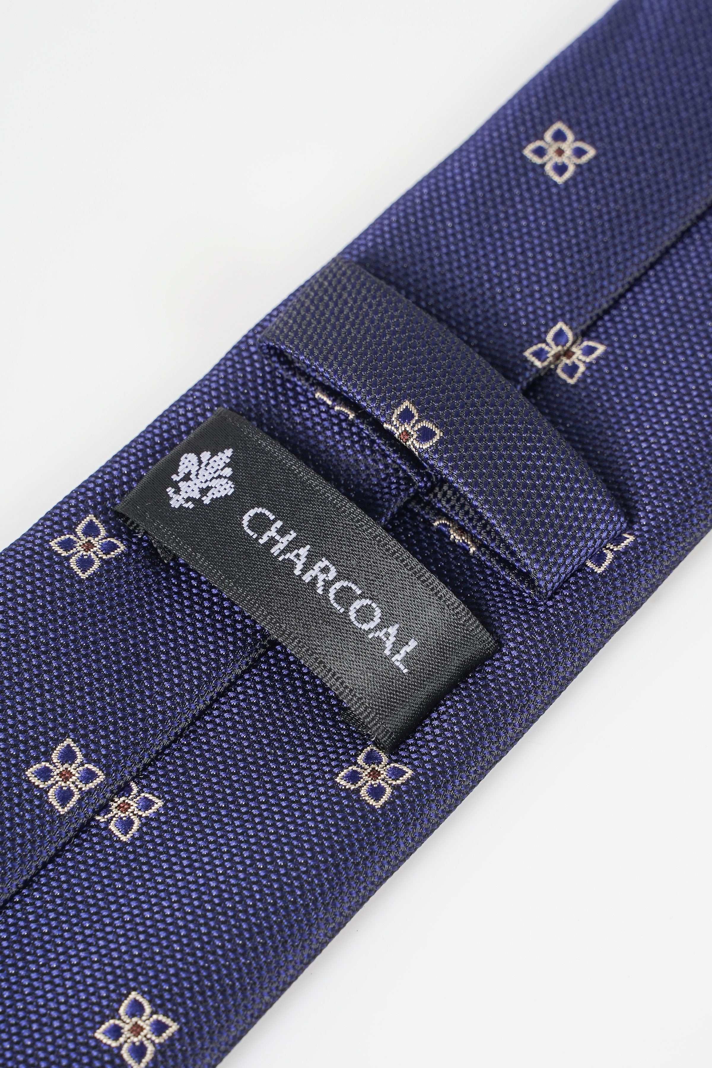 Dark blue necktie with CHARCOAL label and small gold geometric pattern