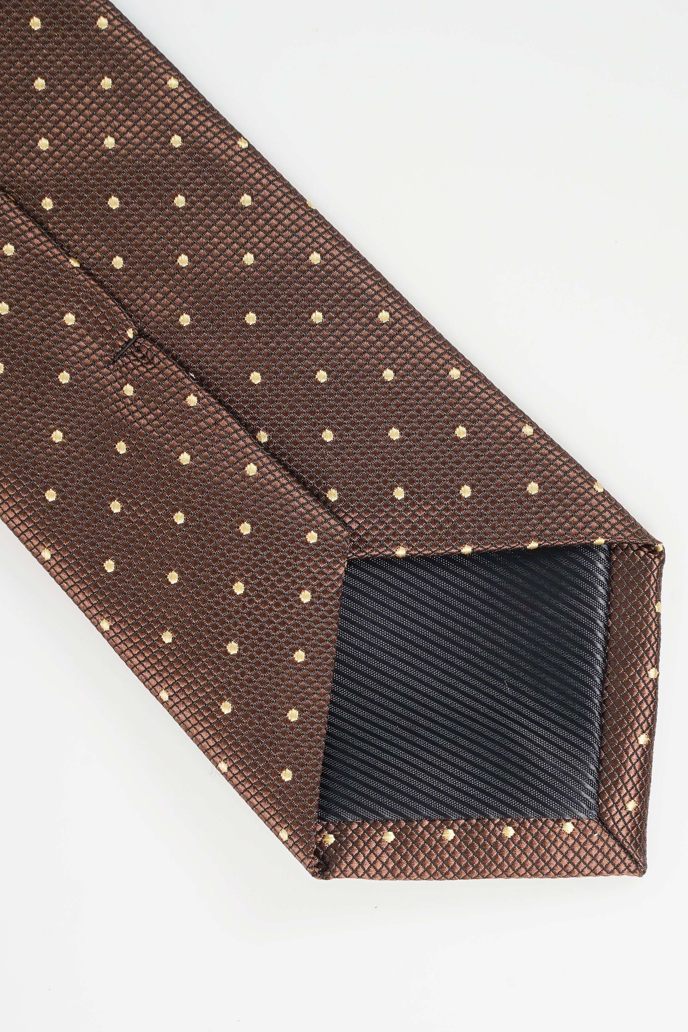 Brown necktie end with gold dot pattern, folded corner close-up