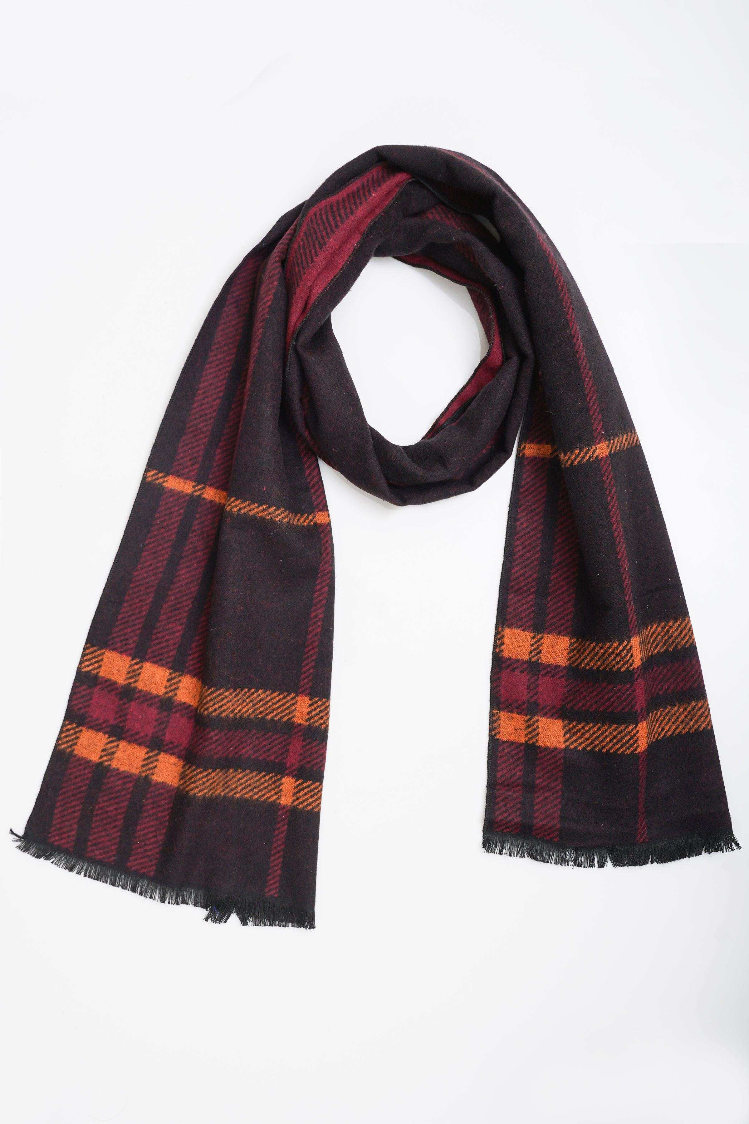Plaid scarf draped in dark burgundy, navy, and orange with fringed hem
