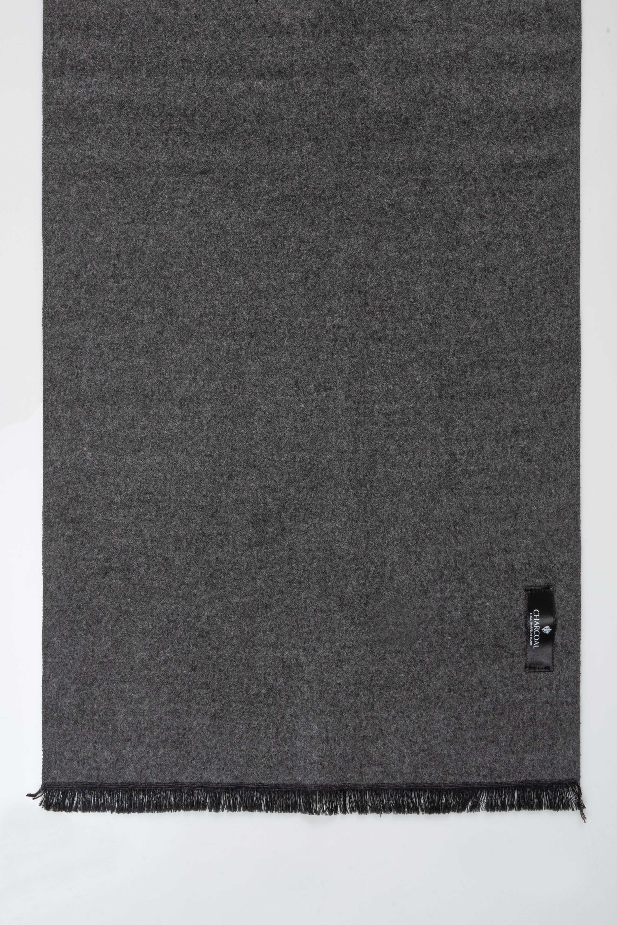 Charcoal gray scarf with frayed hem, close-up view of one end