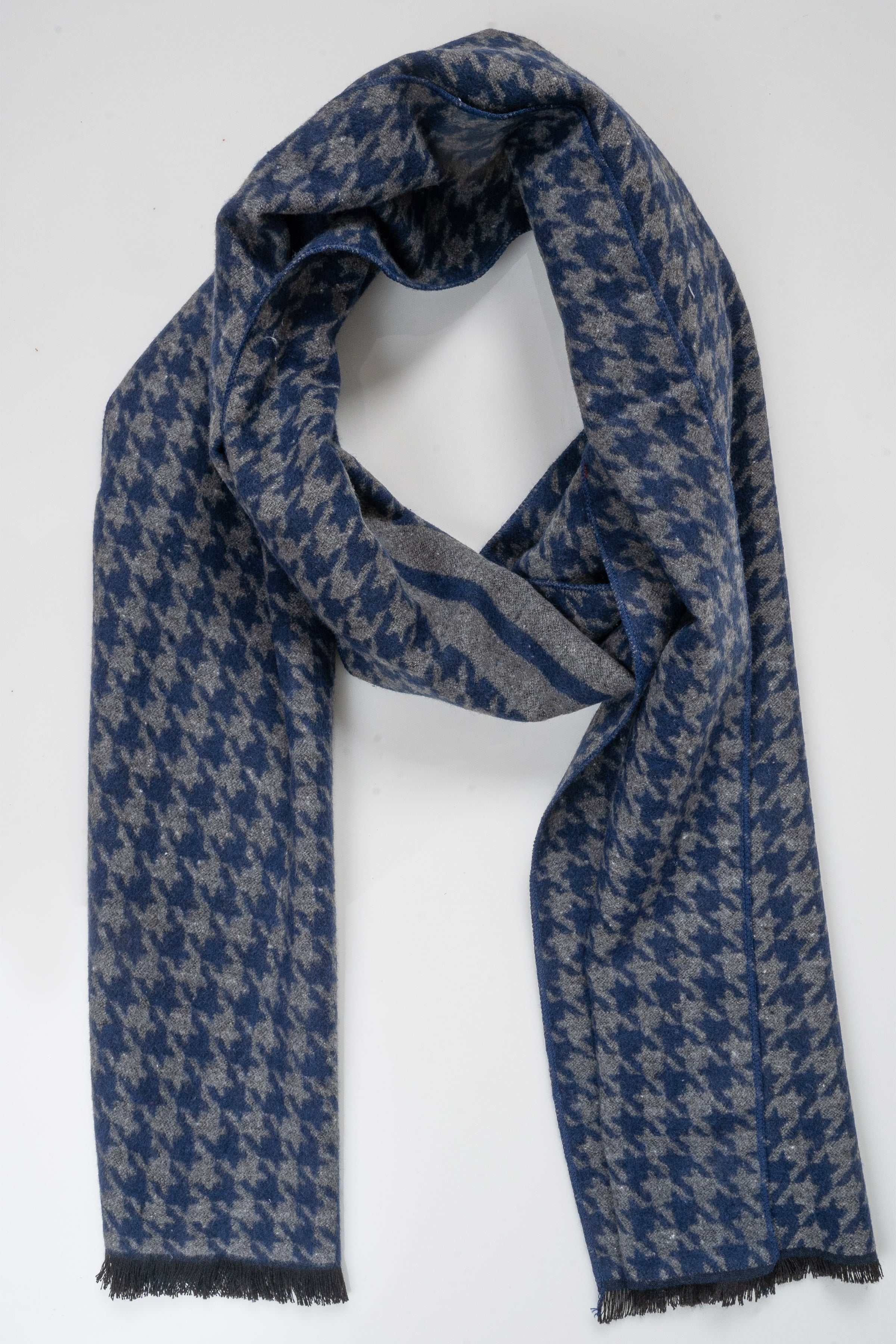 Blue patterned scarf draped on itself, with fringed ends and striped accent