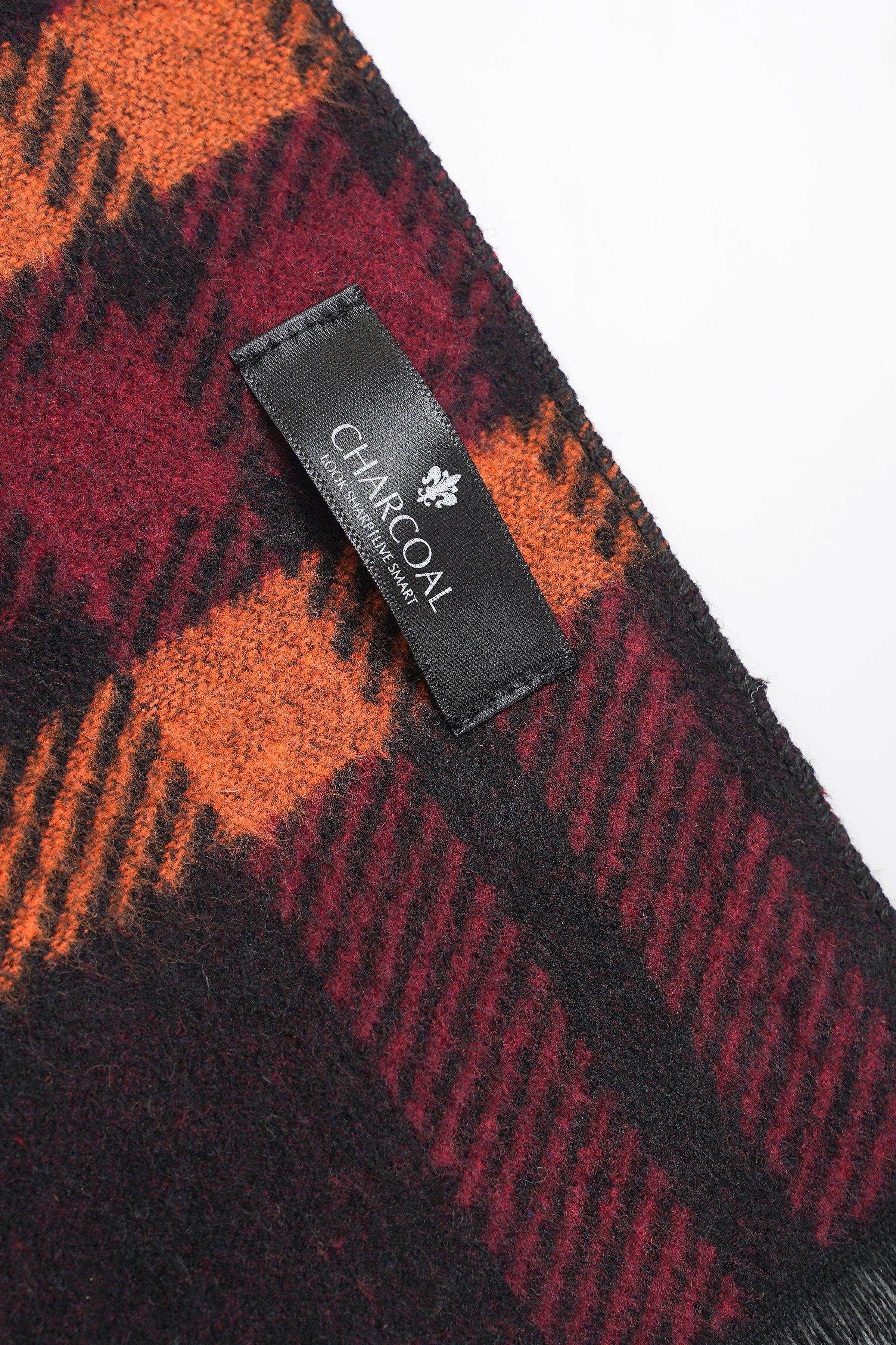 Plaid scarf corner with brand label, dark burgundy and orange tones, fringe edge