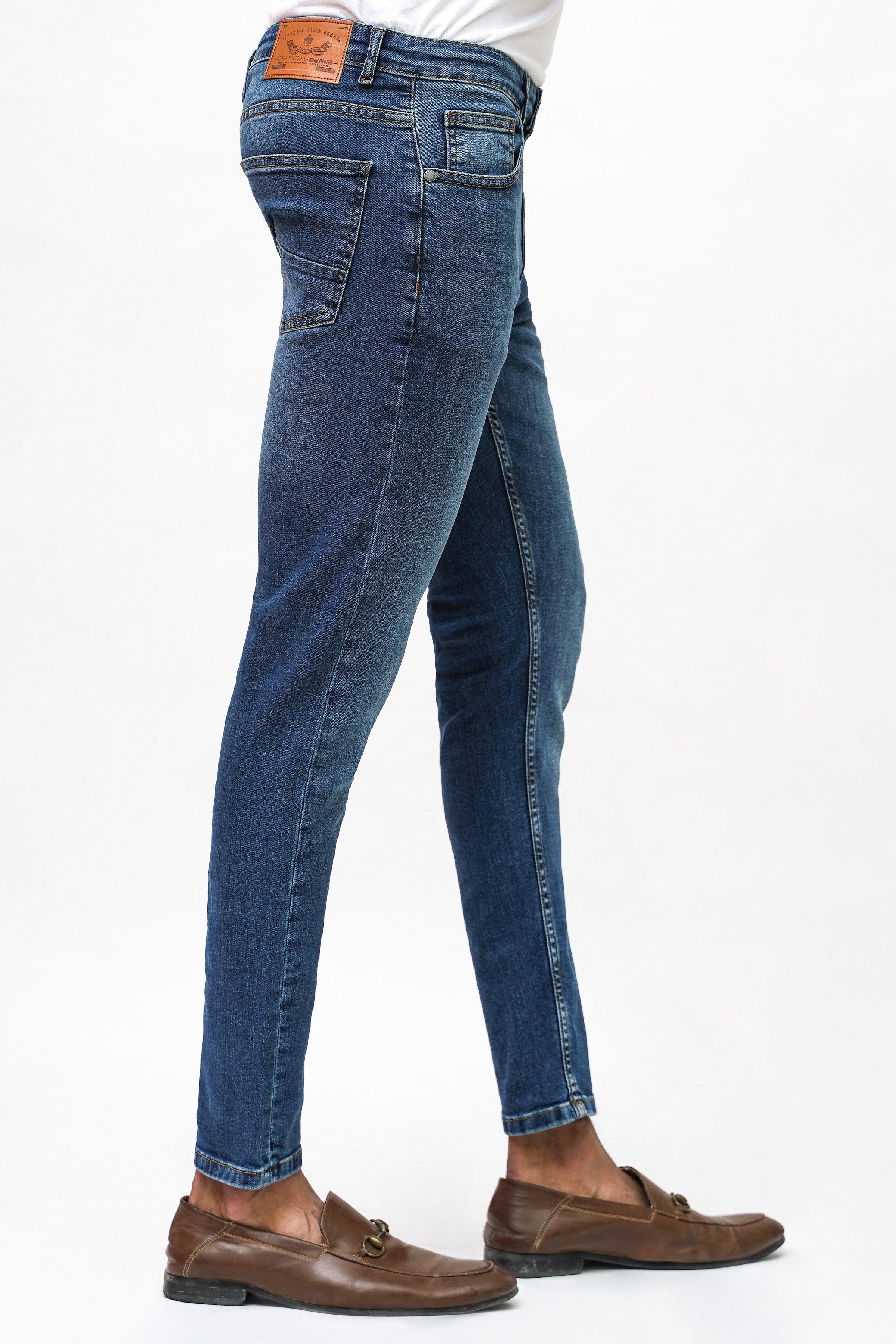 Mid blue skinny-fit denim jeans, faded wash, slim tapered legs, button closure.