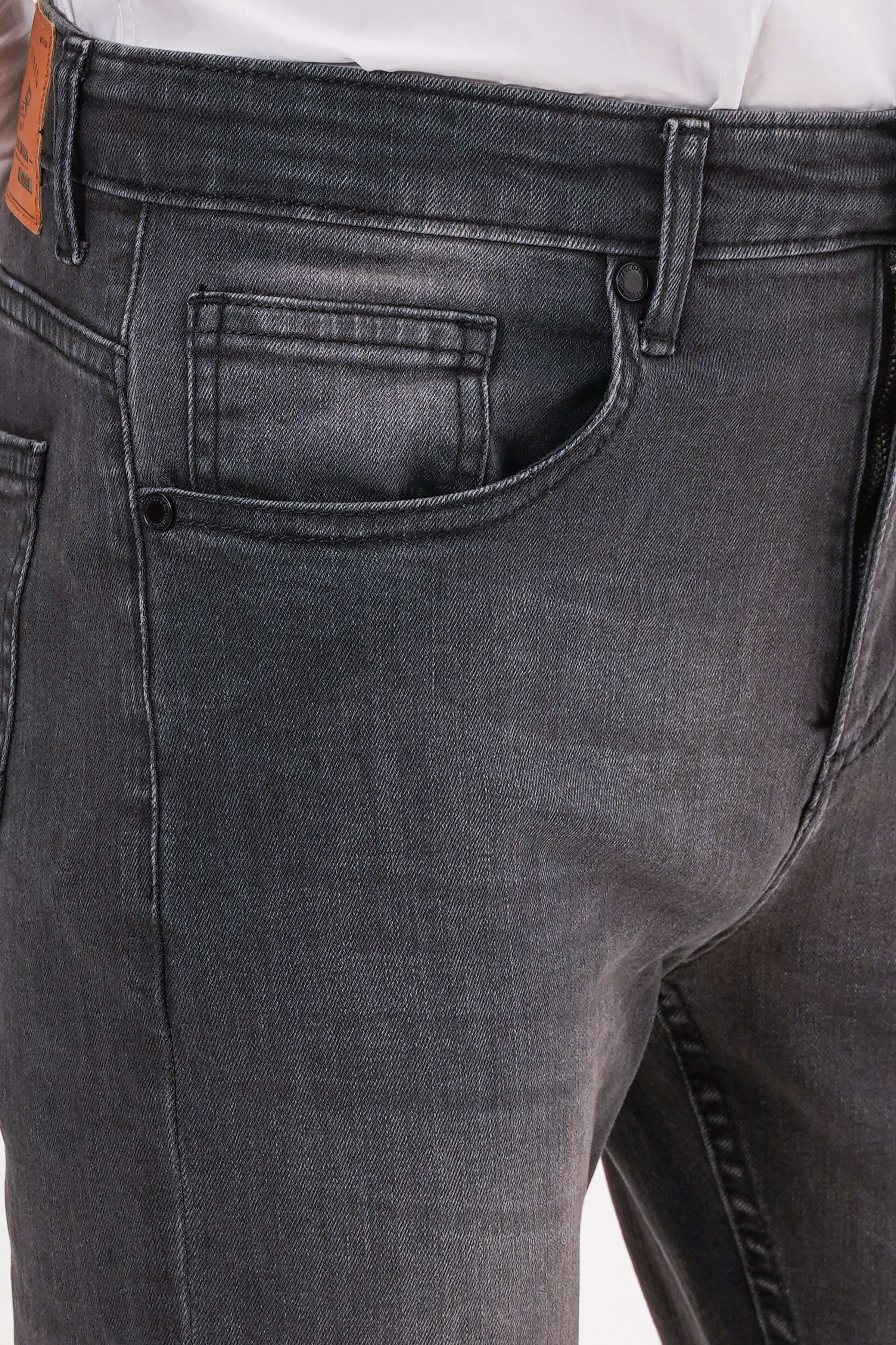 Dark grey slim-leg jeans close-up of front pocket, waistband, and button